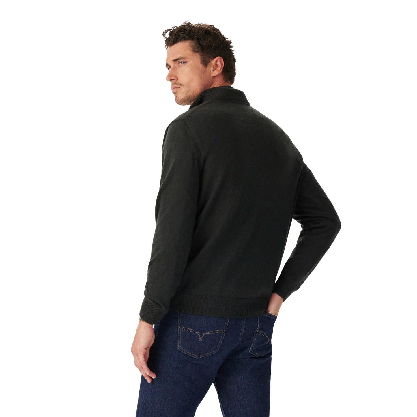 A man wearing a black long-sleeve quarter-zip pullover sweater, shown from a three-quarters back view, paired with dark blue jeans against a solid white background.