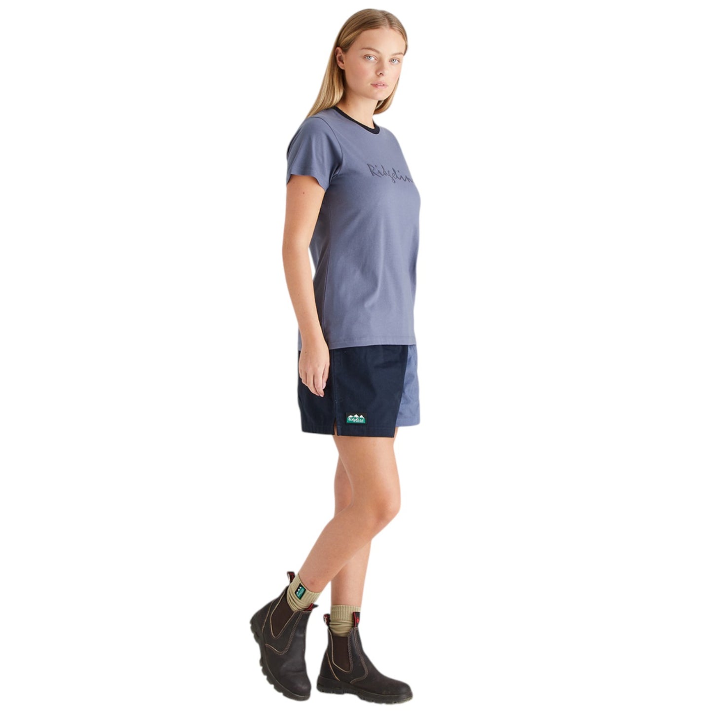 Woman wearing a blue t-shirt and black shorts on a white background