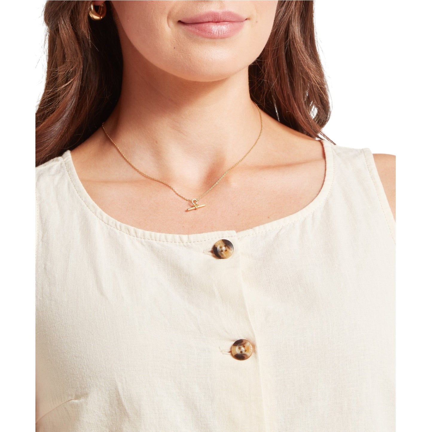 Woman wearing a gold necklace with a delicate chain design.