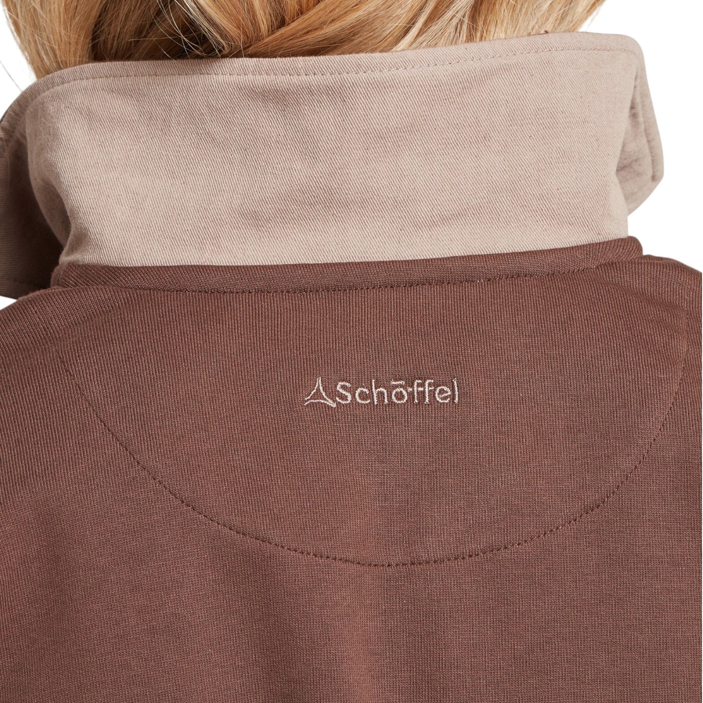 Close-up of a brown jacket with a beige collar, featuring the Schoffel logo.