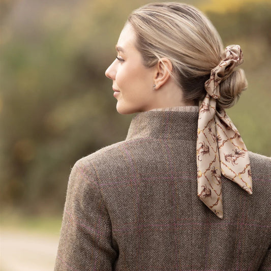 Woman wearing a patterned scarf in her hair with a blurred natural background
