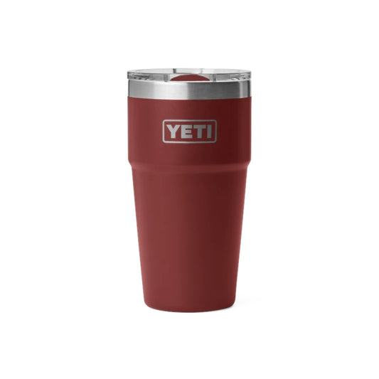 A YETI insulated travel tumbler in matte burgundy red with a silver stainless steel rim and a clear lid, shown on a plain white background.