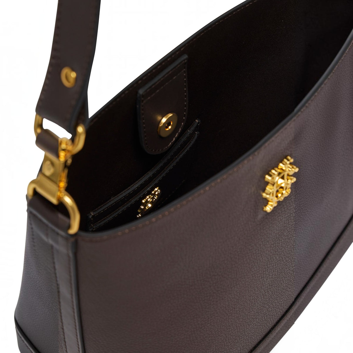 Close-up of a dark brown pebbled leather shoulder bag showing the interior, a side pocket with gold hardware, and a gold monogram logo on the exterior.