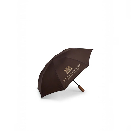 A dark brown open umbrella with gold printed text reading Holland Cooper and a small crest logo, shown on a clean white background.