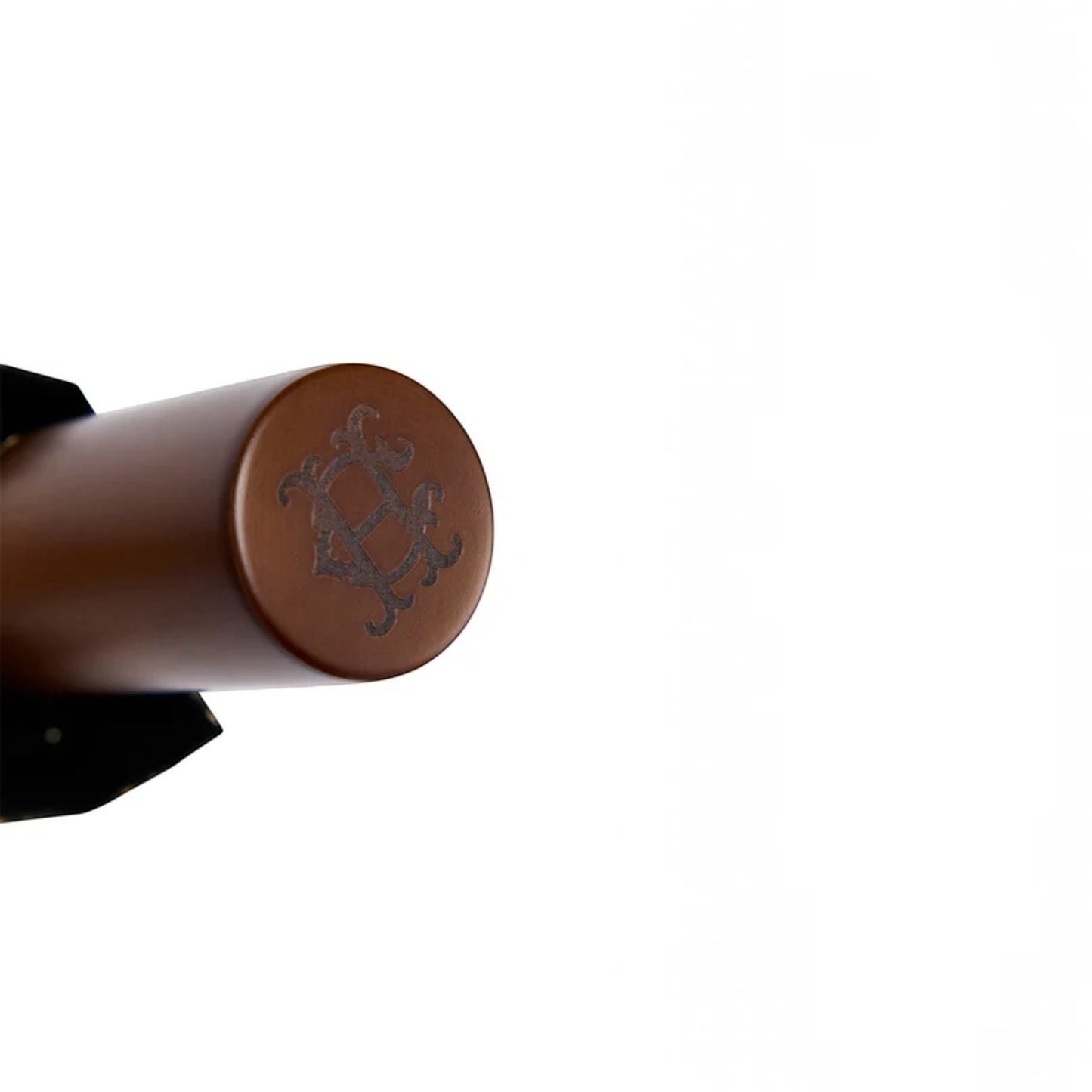 Close-up of a brown cylindrical product end cap with an embossed decorative emblem, shown against a plain white background.