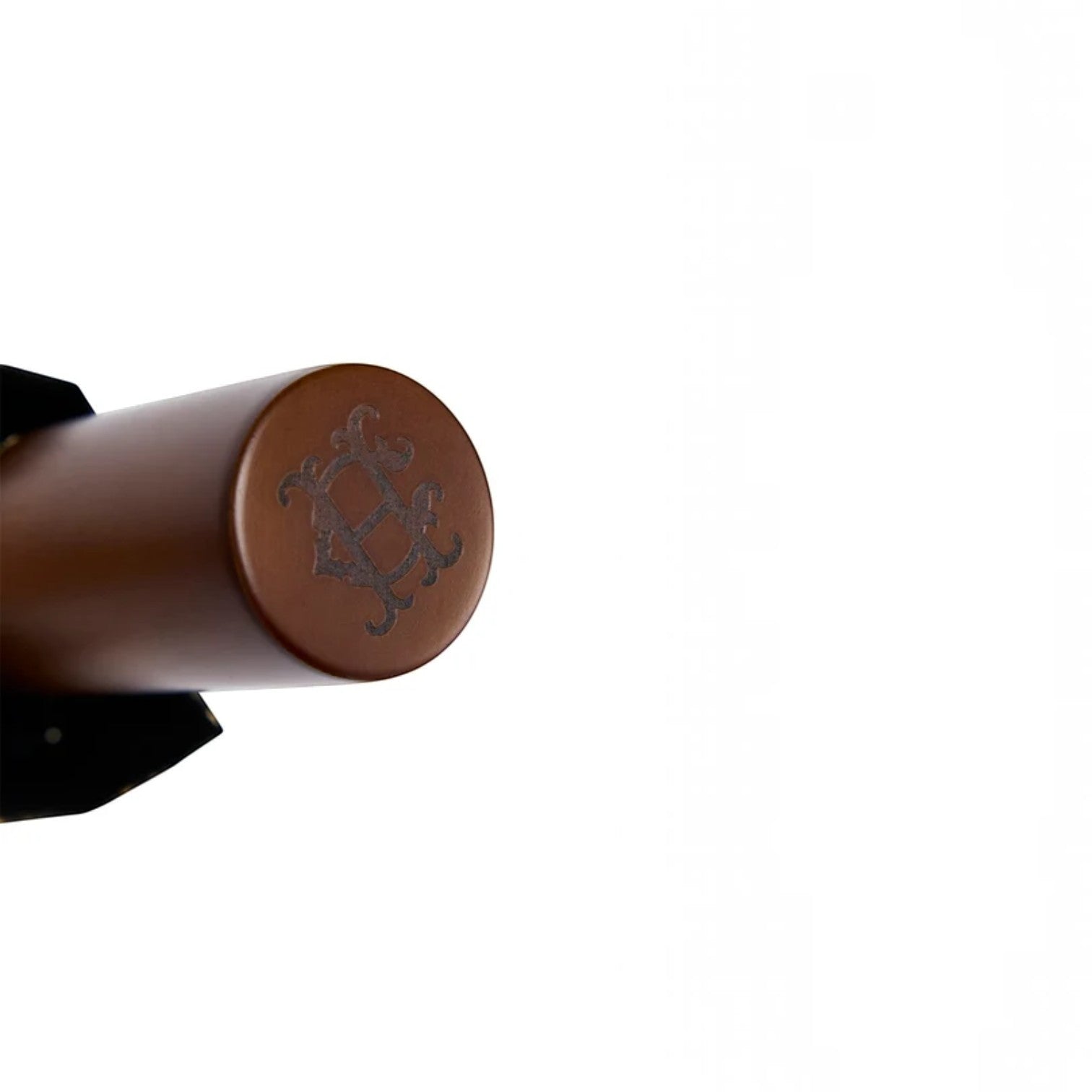 Close-up of a brown cylindrical product end cap with an embossed decorative emblem, shown against a plain white background.