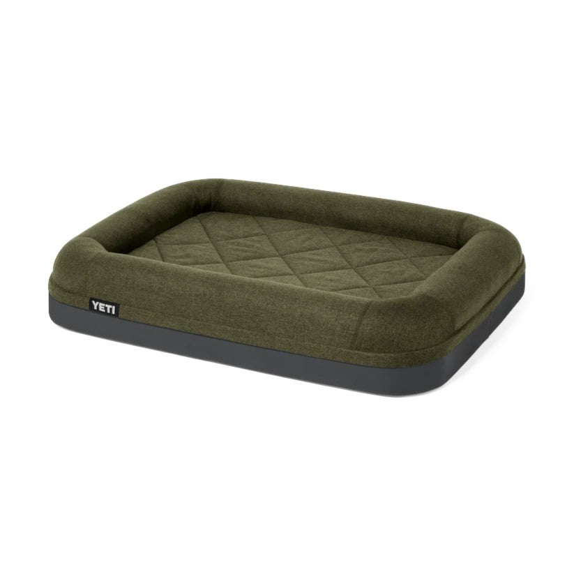 An olive green YETI pet bed with a quilted diamond pattern on the interior and a dark gray base, shown on a plain white background.
