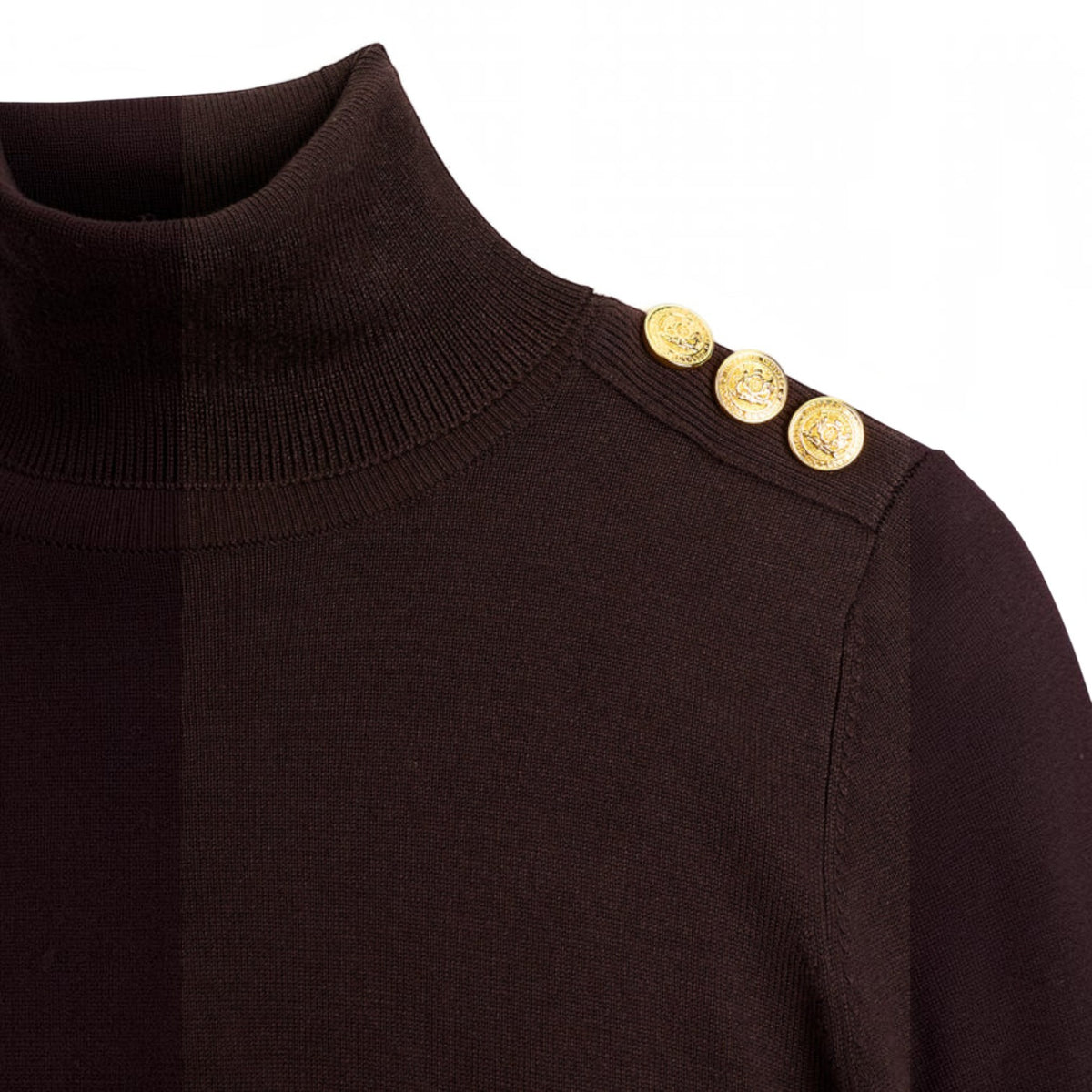 Close-up of a dark brown ribbed turtleneck sweater featuring three decorative gold buttons on the shoulder, set against a plain white background.