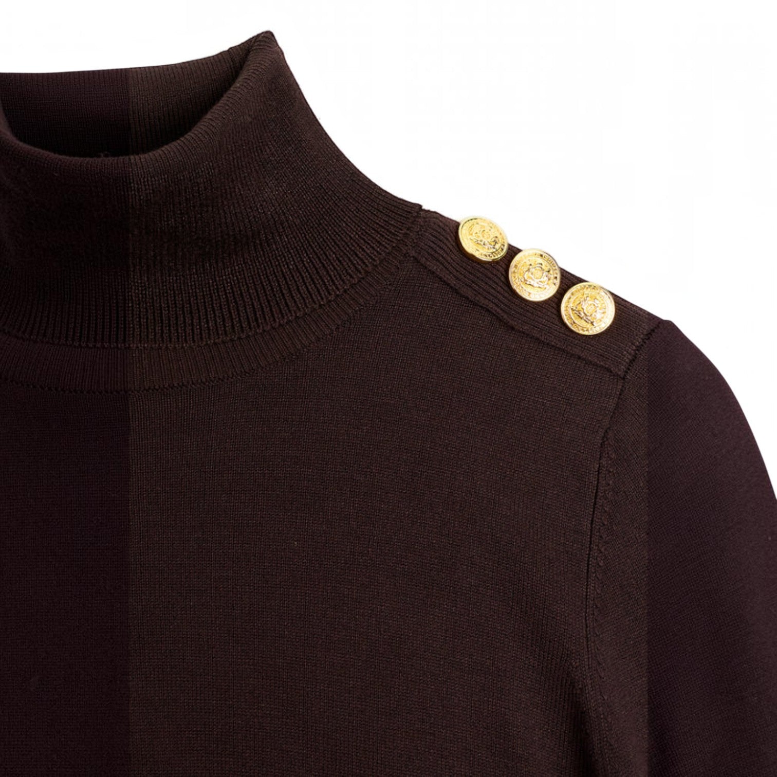 Close-up of a dark brown ribbed turtleneck sweater featuring three decorative gold buttons on the shoulder, set against a plain white background.