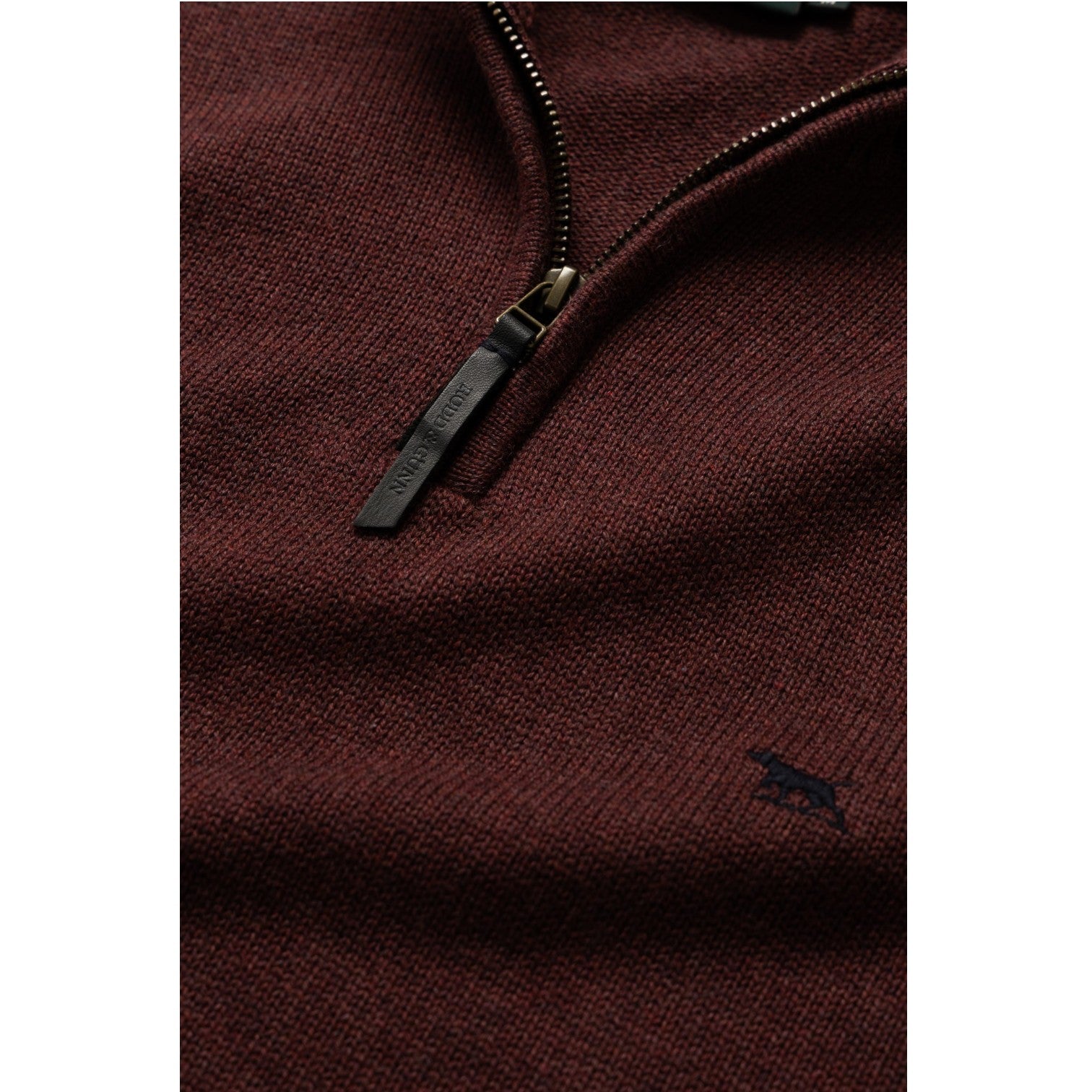 Close-up of a brown zip-up sweatshirt with a brand logo on a white background