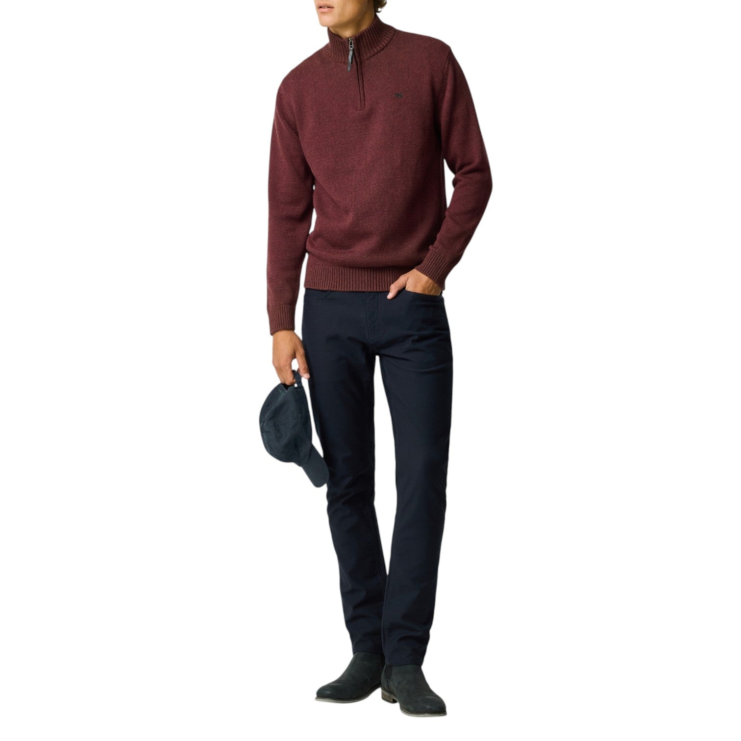 Person wearing a burgundy sweater and dark pants on a white background