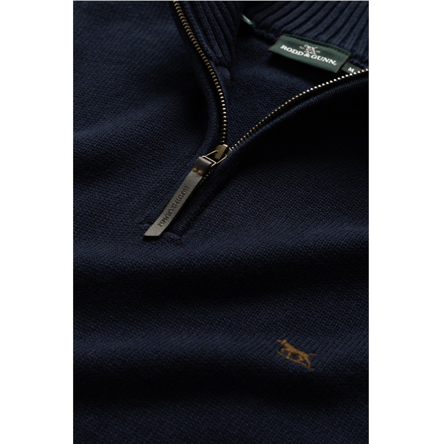 Navy blue sweater with a zipper and brand label on a white background
