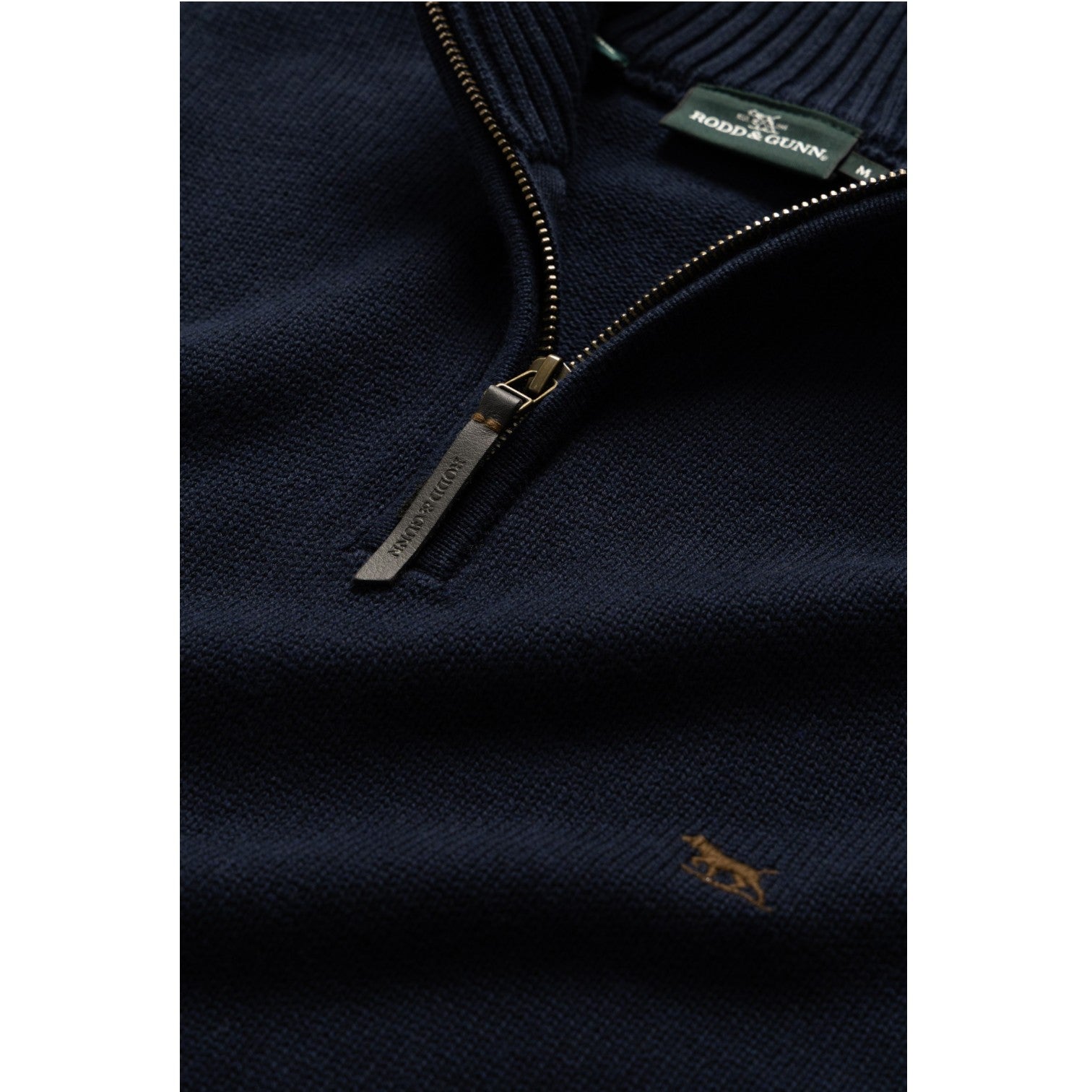 Navy blue sweater with a zipper and brand label on a white background