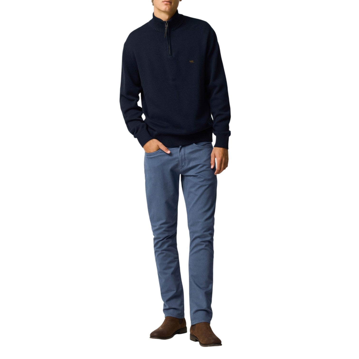 Man wearing a navy sweater and blue jeans on a white background