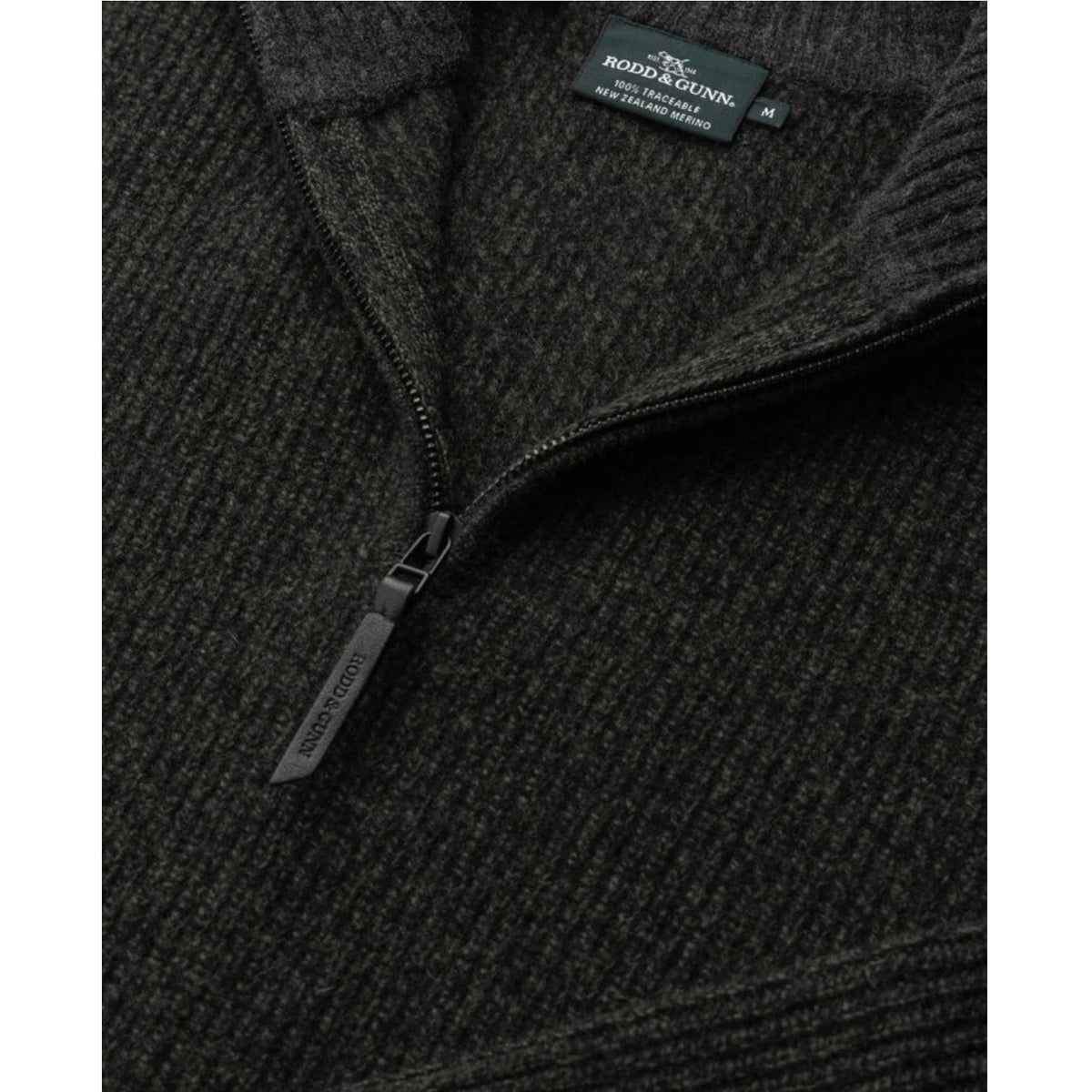 Close-up of a dark gray fleece jacket with a brand label on a white background