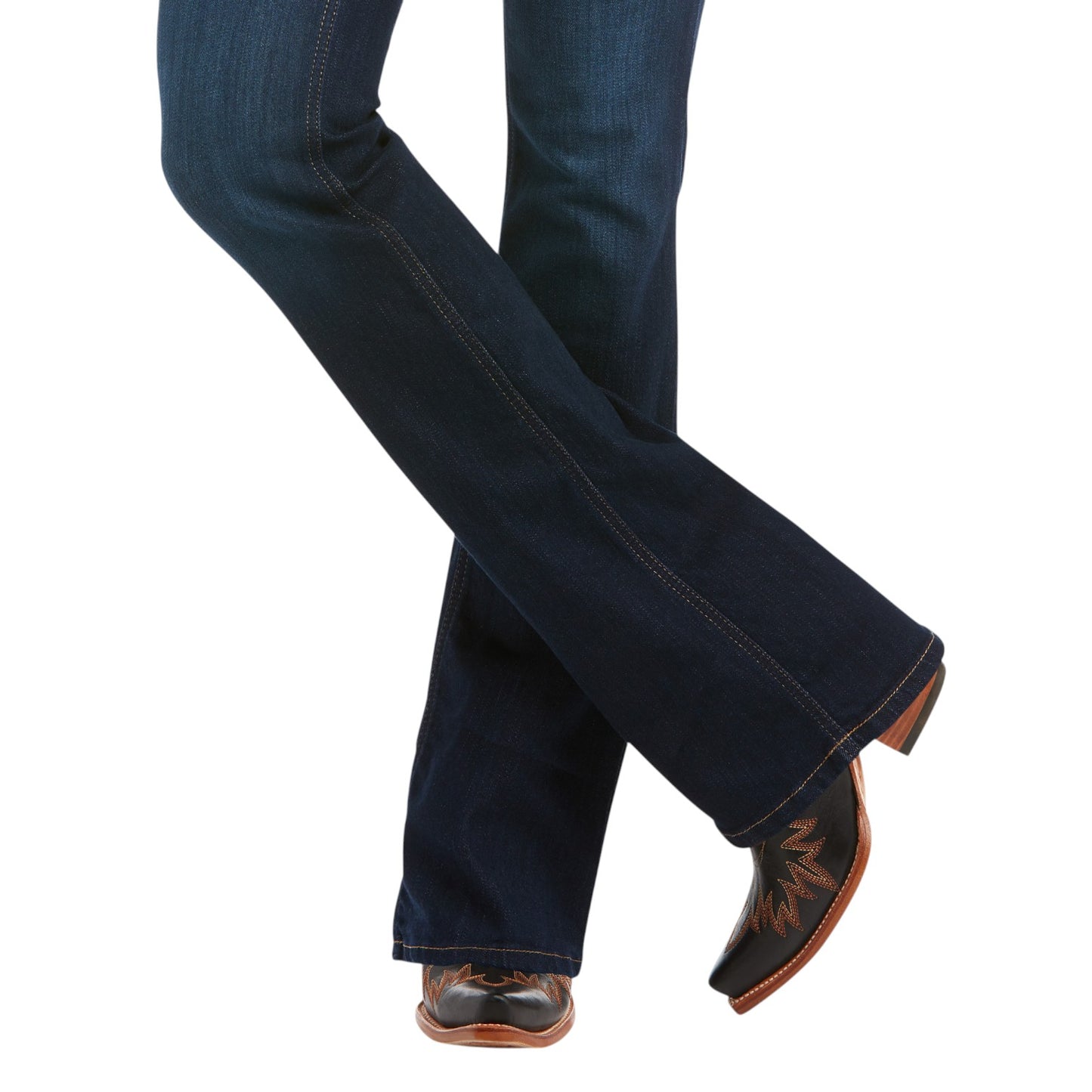 Dark blue jeans worn with brown cowboy boots on a white background