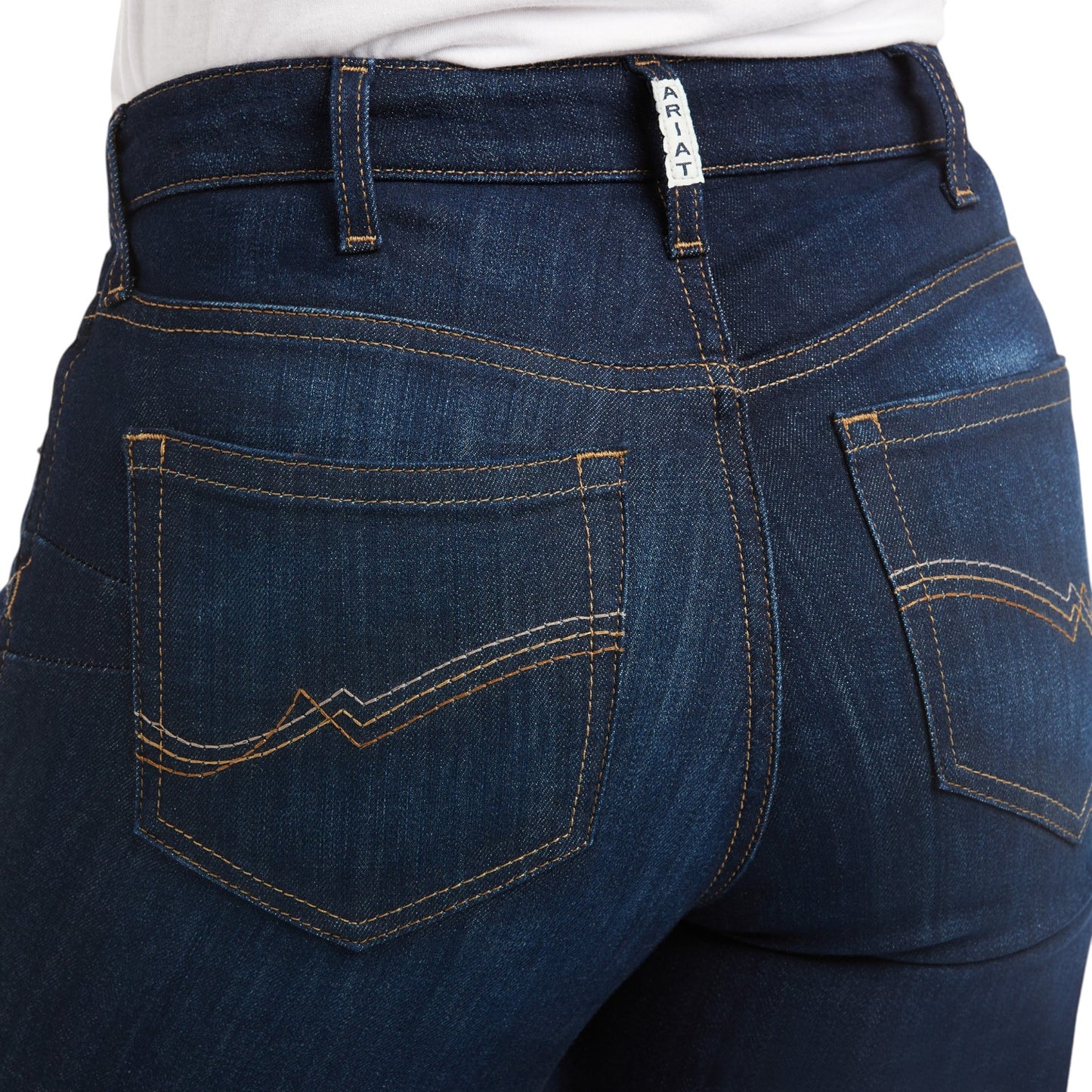 Close-up of blue jeans with a visible brand label on a white background