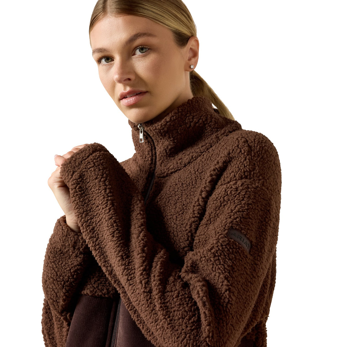 A woman wearing a brown sherpa fleece quarter-zip pullover jacket, photographed against a clean white background.