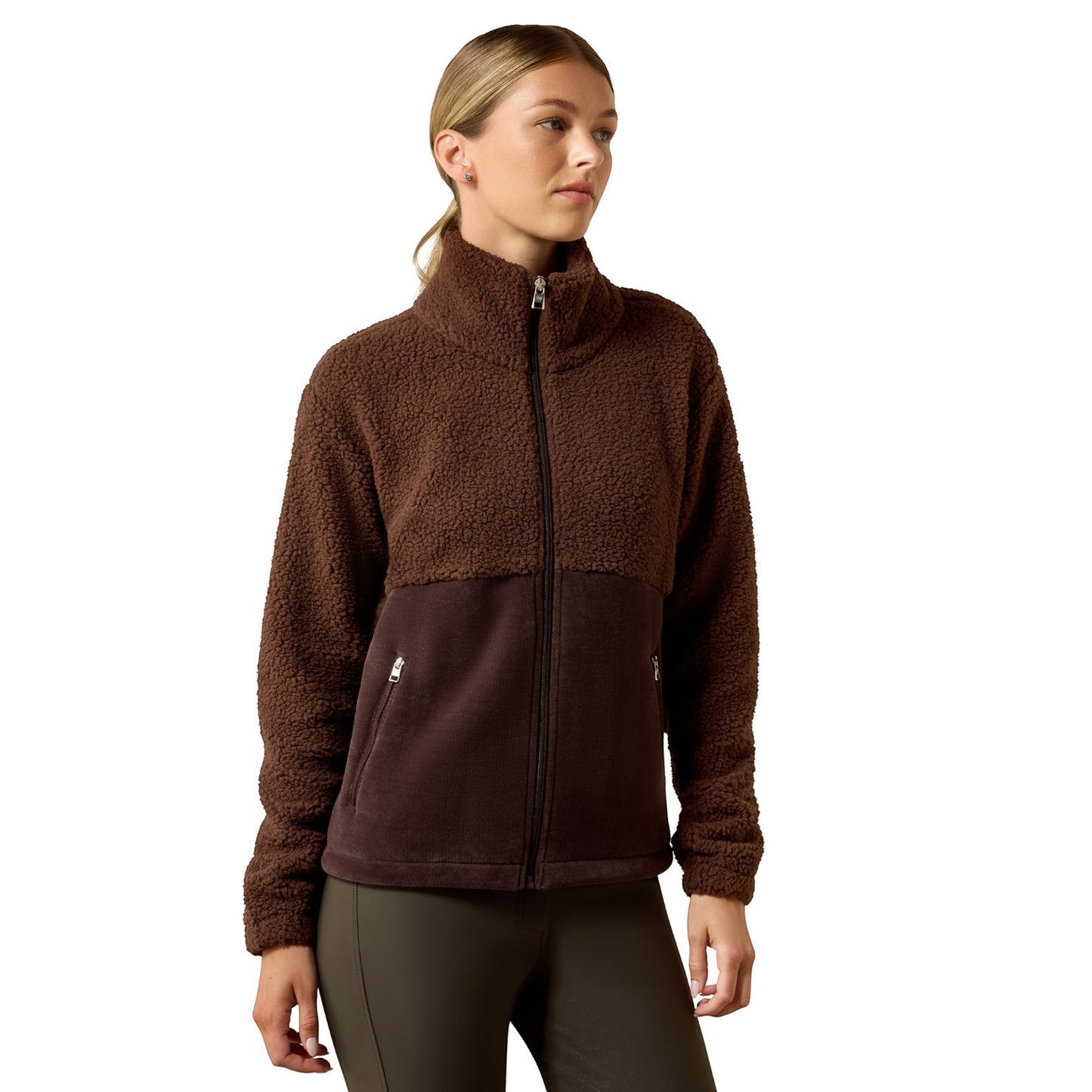A woman wearing a brown fleece jacket with a darker brown lower panel, standing against a plain white background.