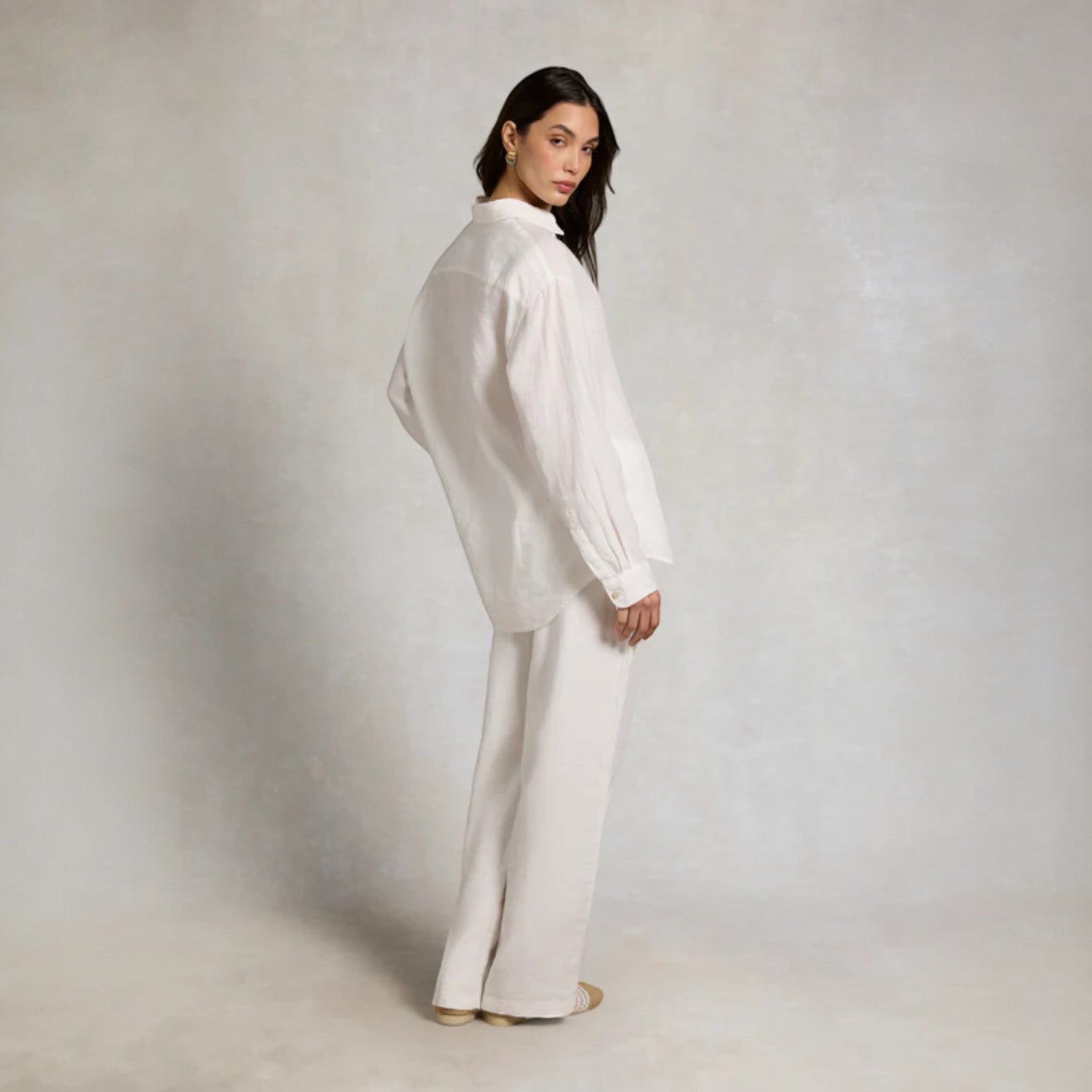 Woman wearing a white outfit against a plain background