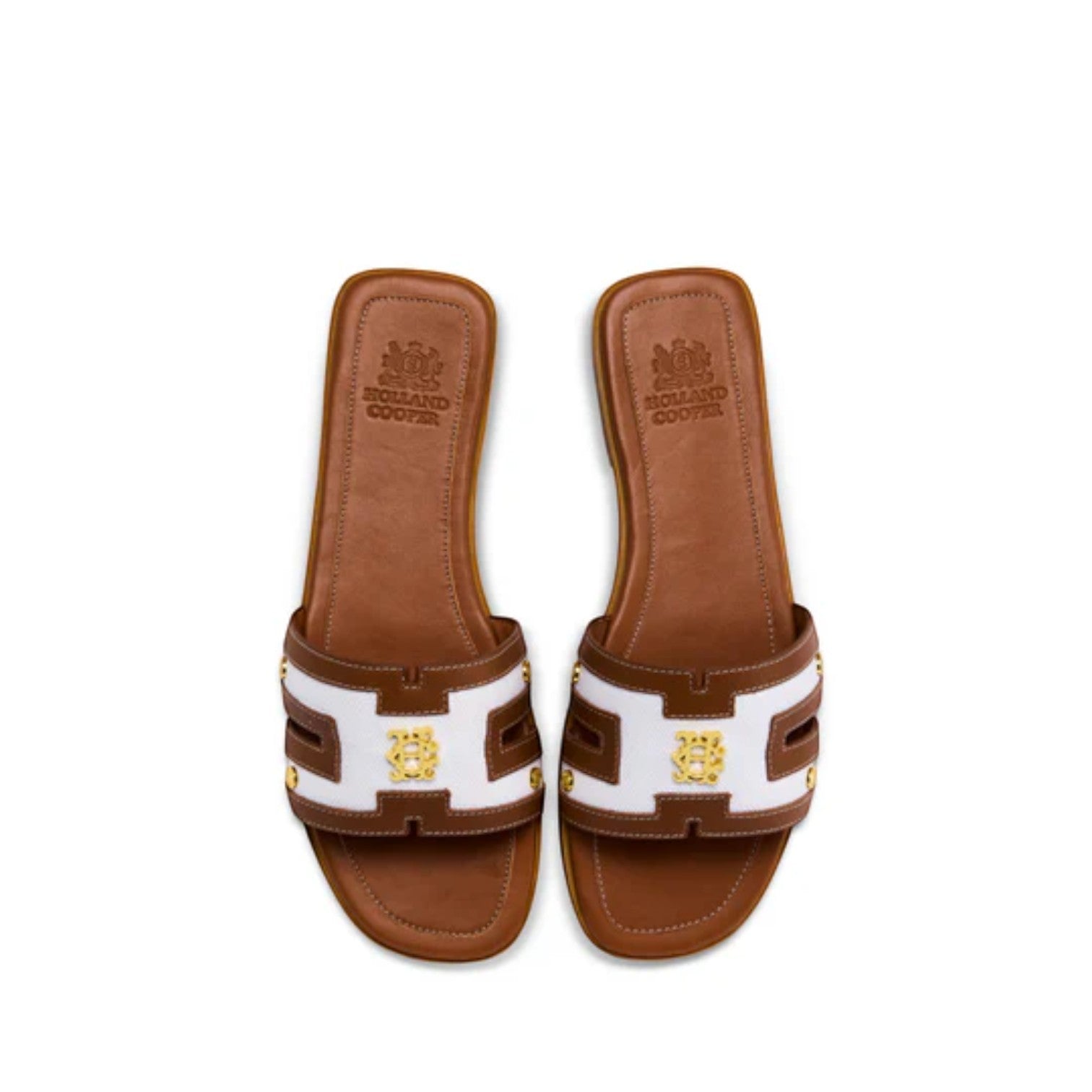 Pair of brown sandals with white and gold accents on a white background