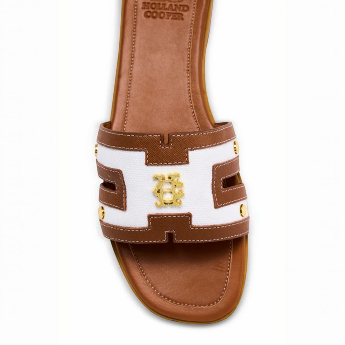 Brown and white sandal with gold accents on a white background