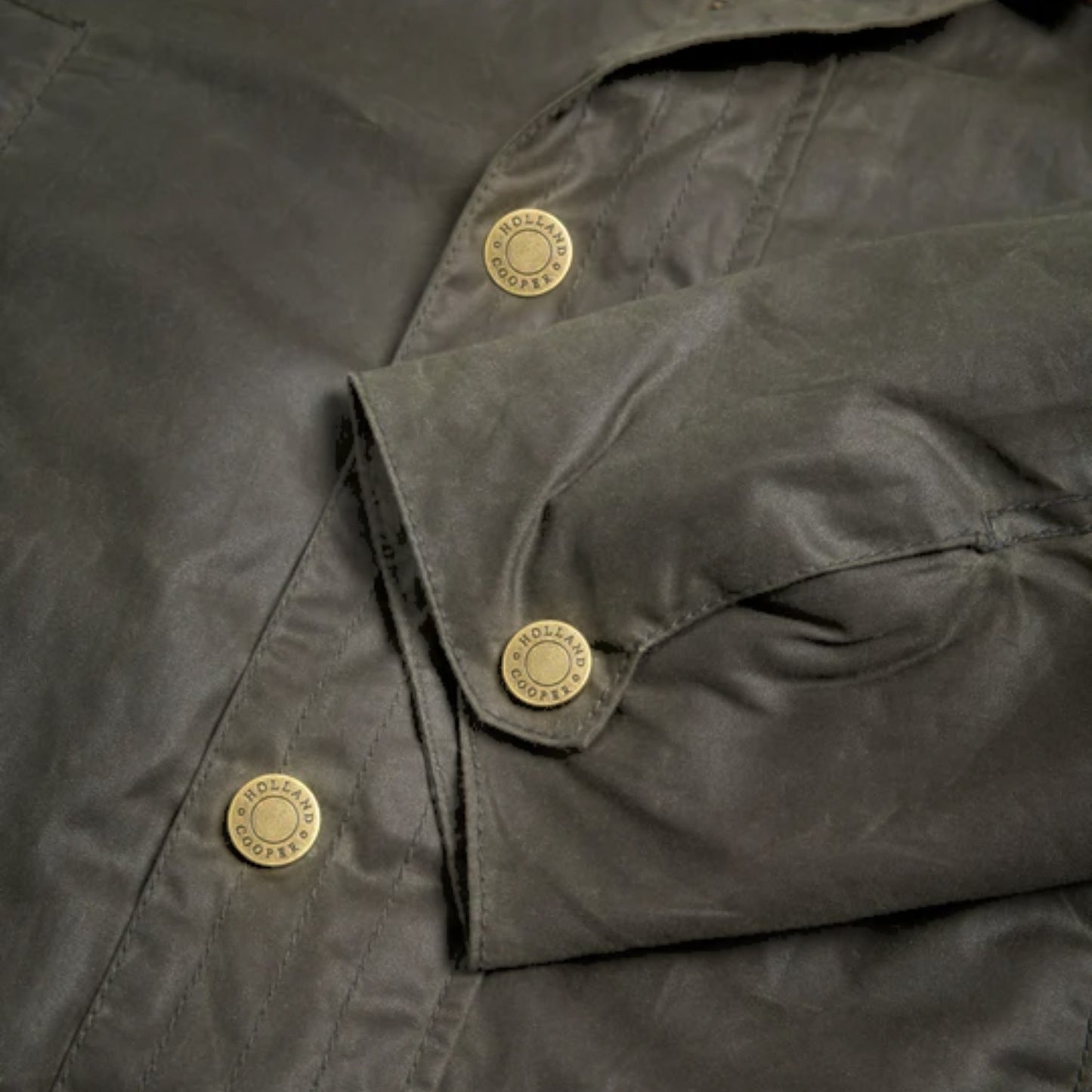 Close-up of a dark green jacket with gold buttons