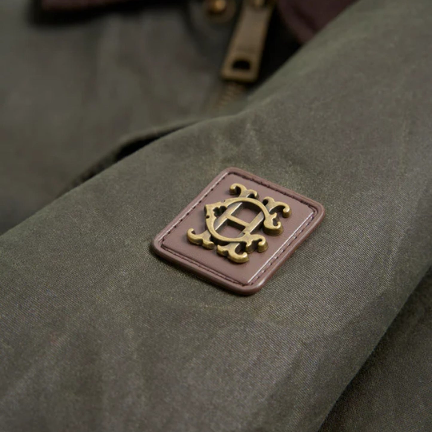 Close-up of a textured fabric surface with a gold emblem on a green background