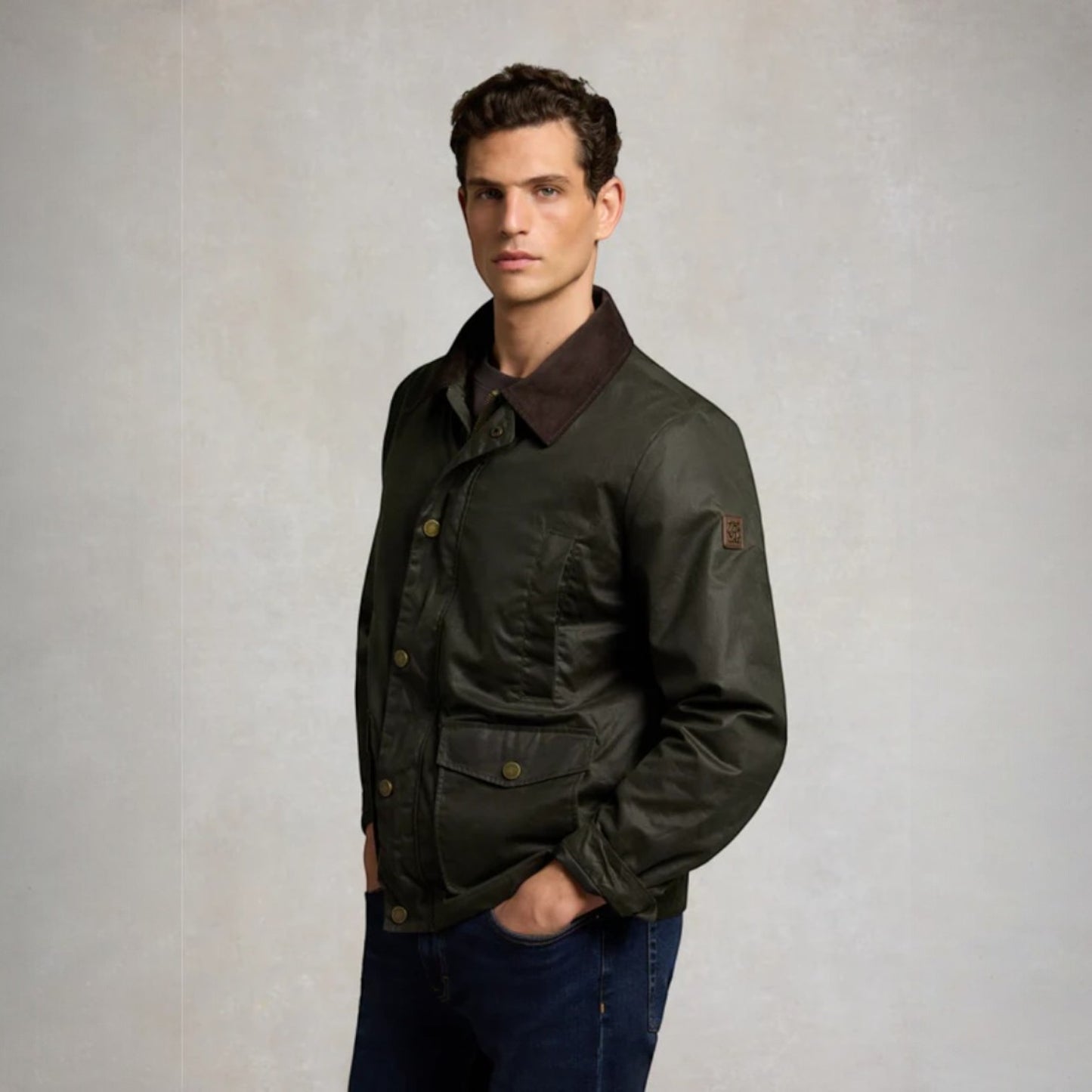Man wearing a dark green jacket with a brown collar against a plain background