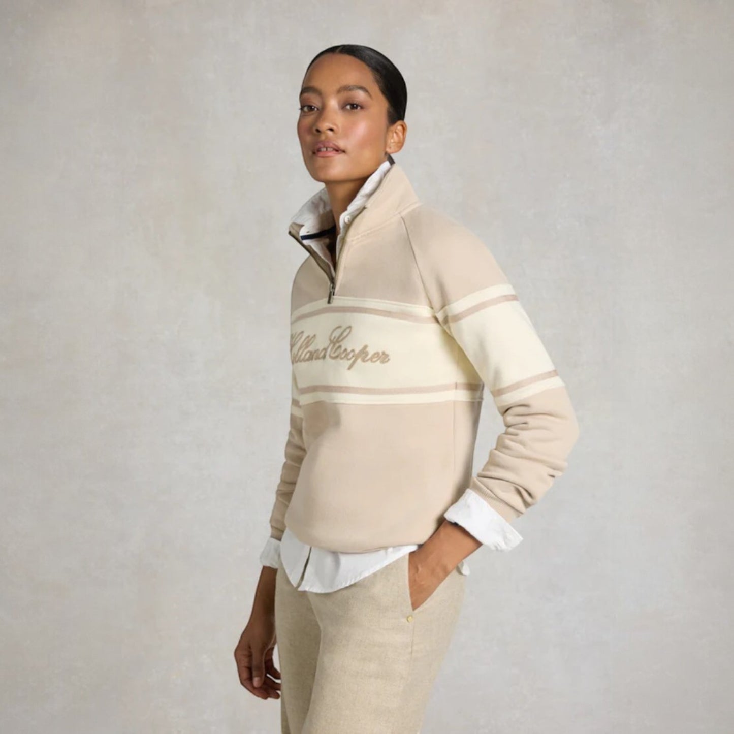 Woman wearing a beige and brown striped sweater with 'Chilewich' branding on a plain background
