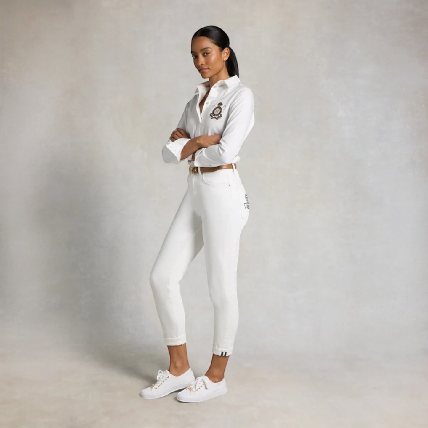 Person wearing a white outfit with a belt on a plain background