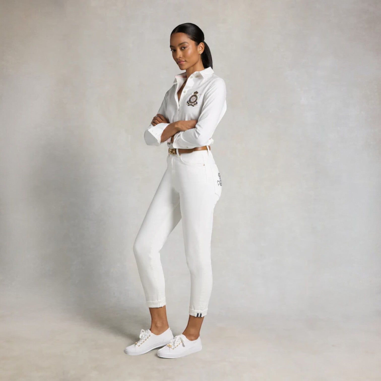 Person wearing a white outfit with a belt on a plain background
