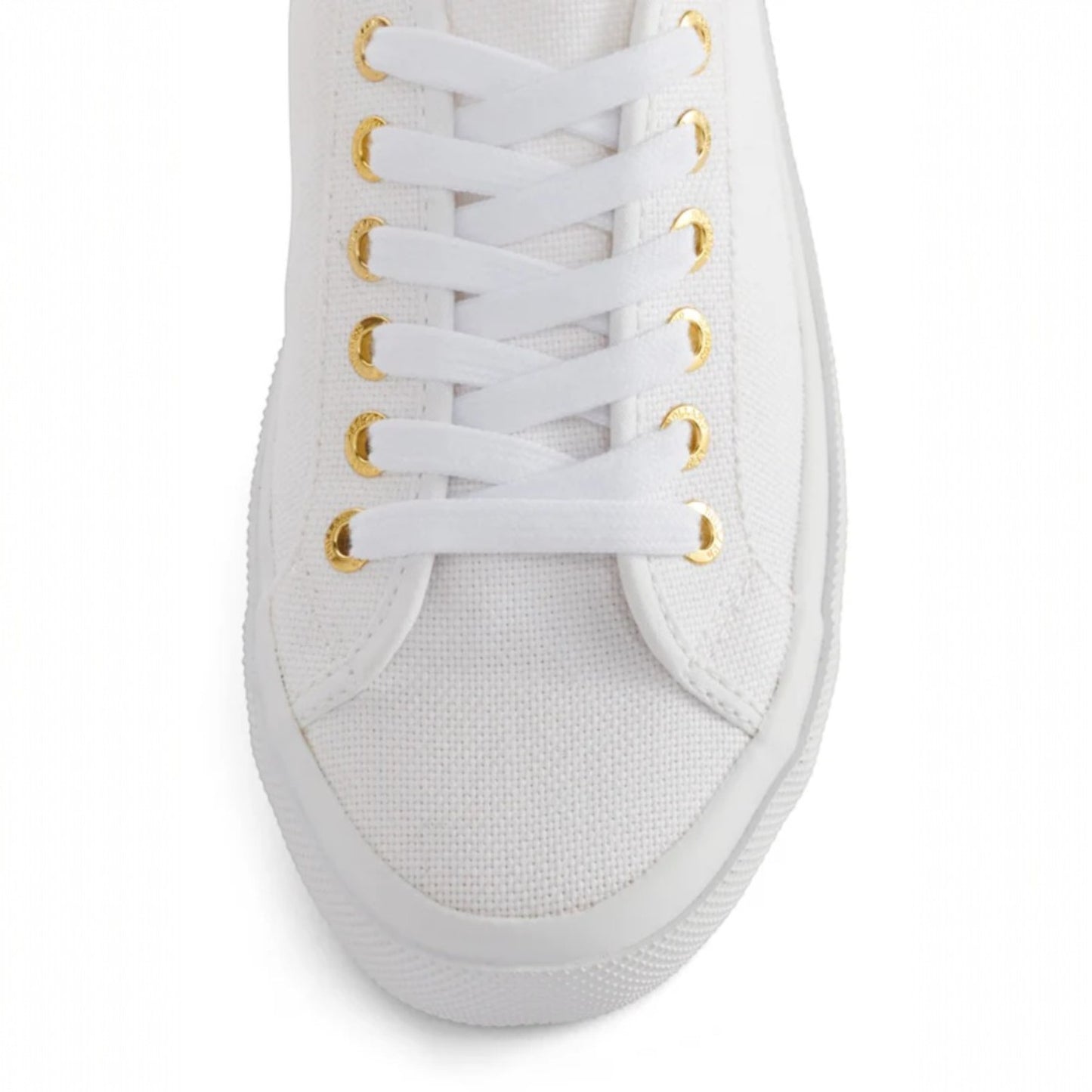 White sneaker with gold eyelets on a white background