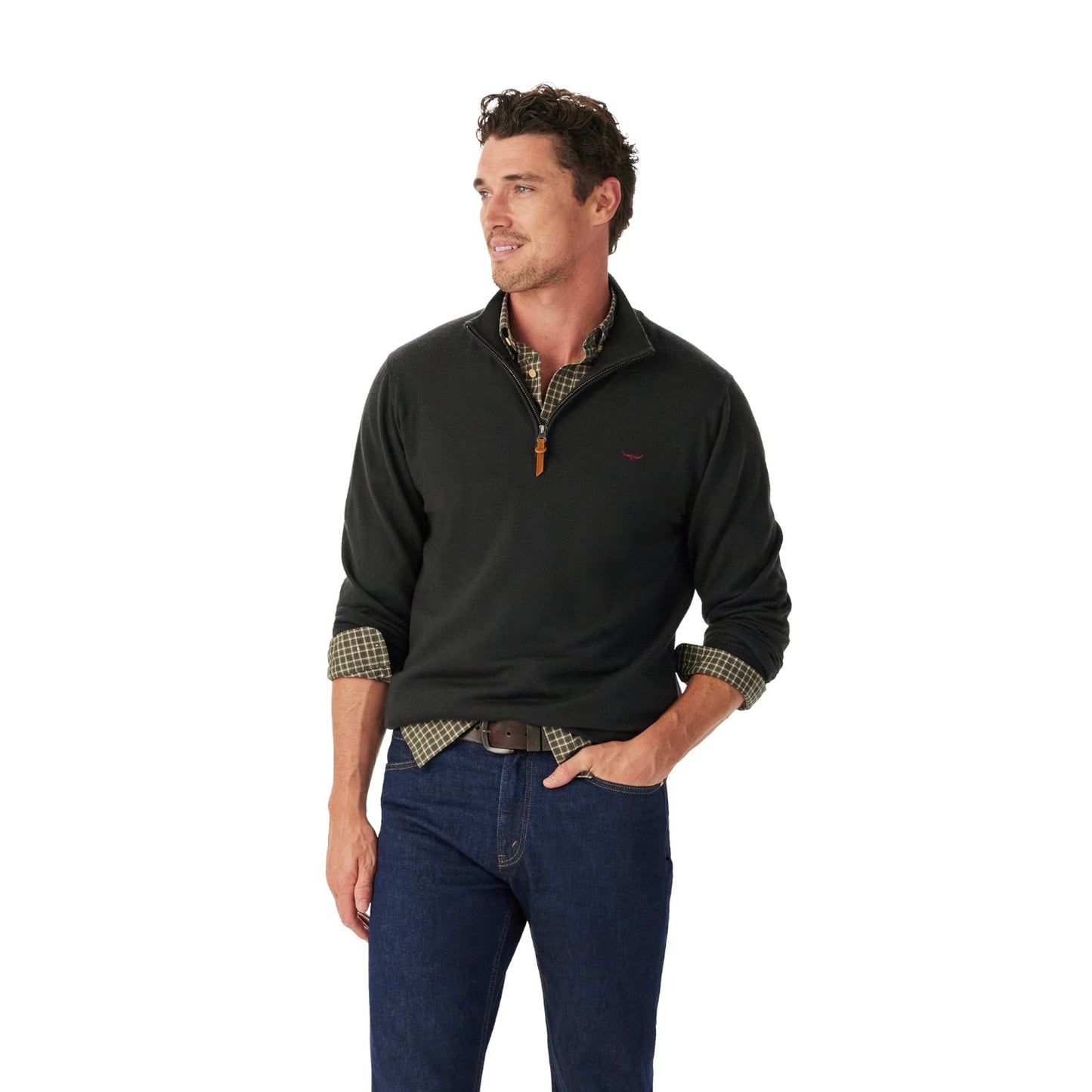 Man wearing a black pullover with plaid accents and blue jeans on a white background