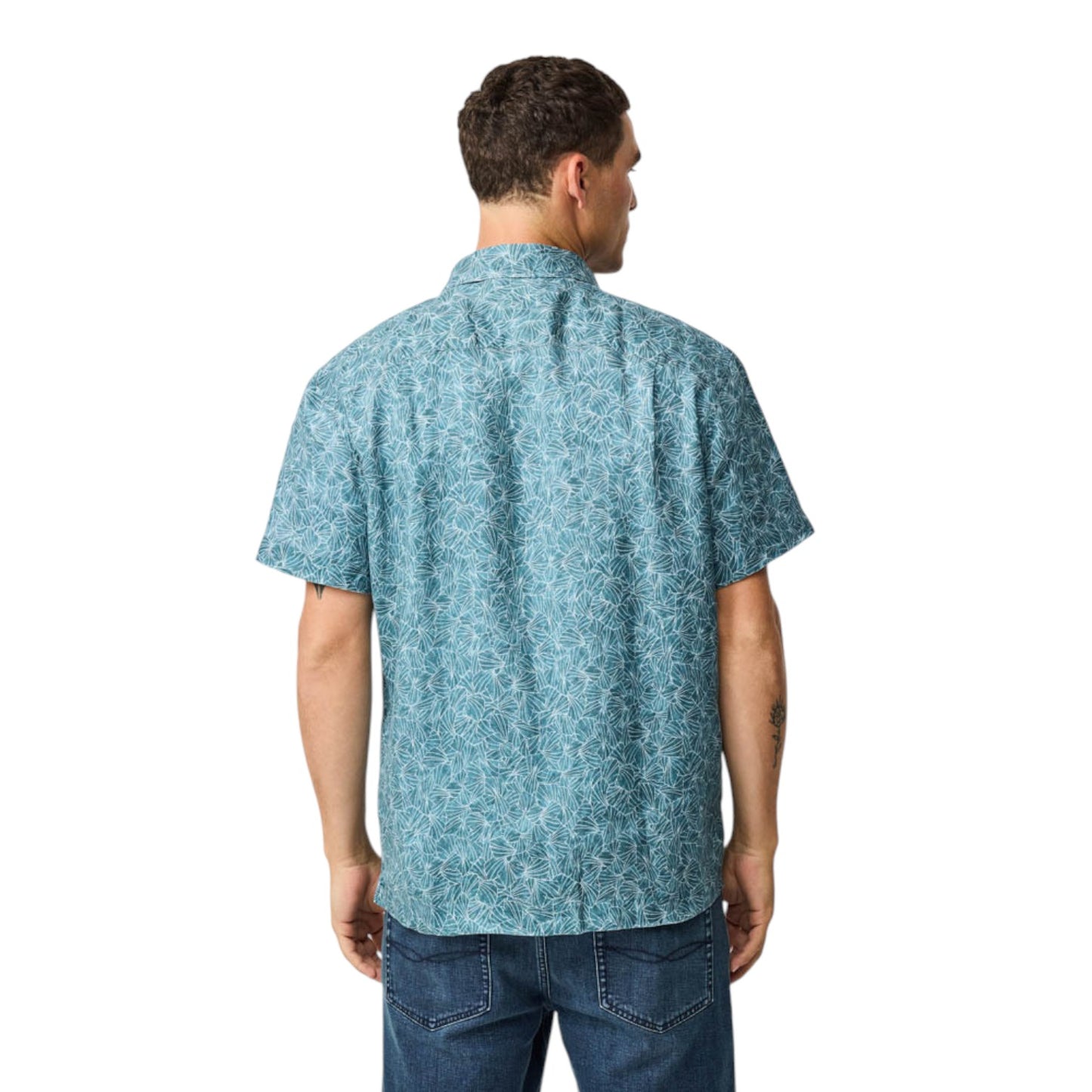 Man wearing a blue patterned shirt and jeans on a white background