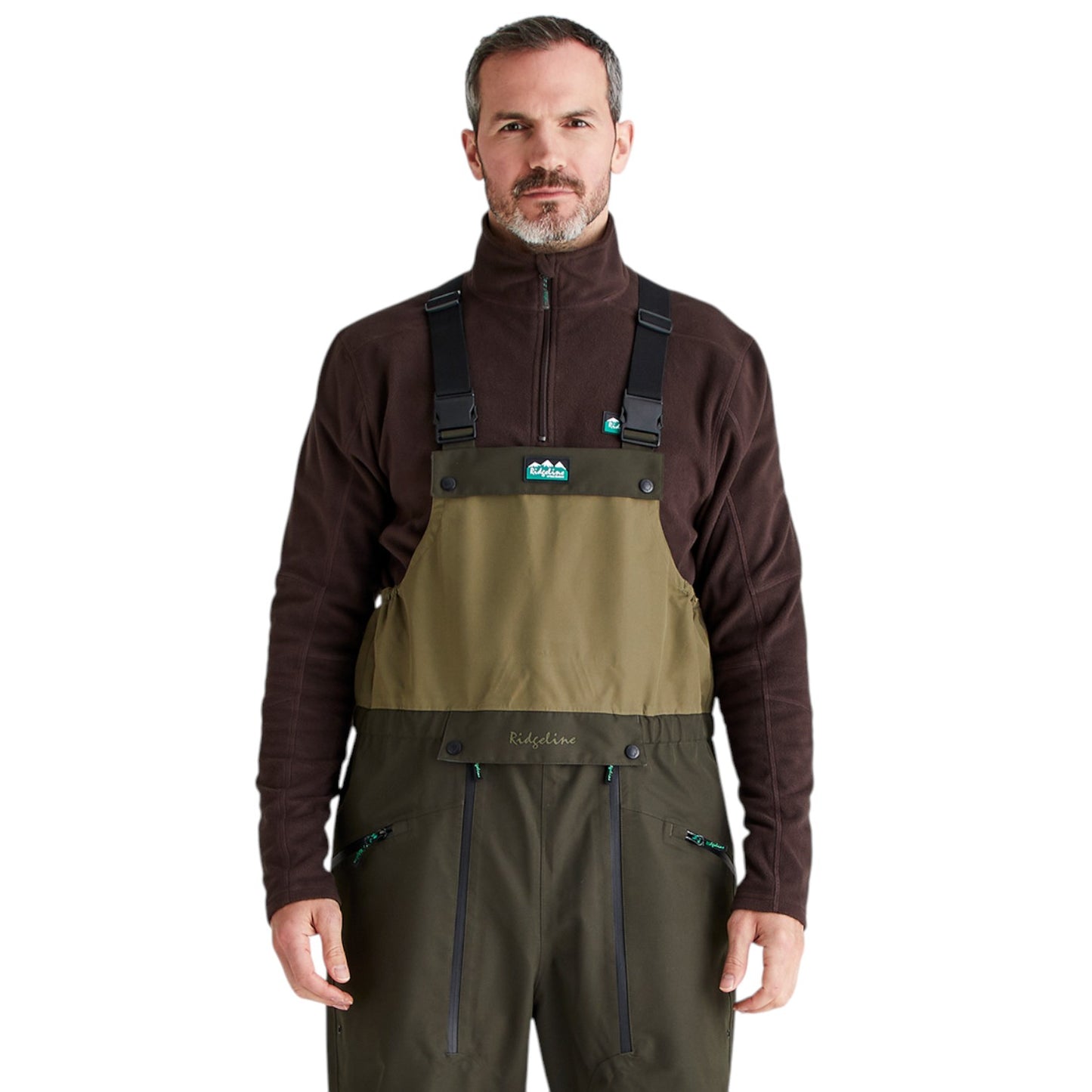 A man wearing a pair of outdoor waders over a dark brown quarter-zip fleece top, photographed against a solid white background. The waders feature a tan chest panel and dark olive green legs.