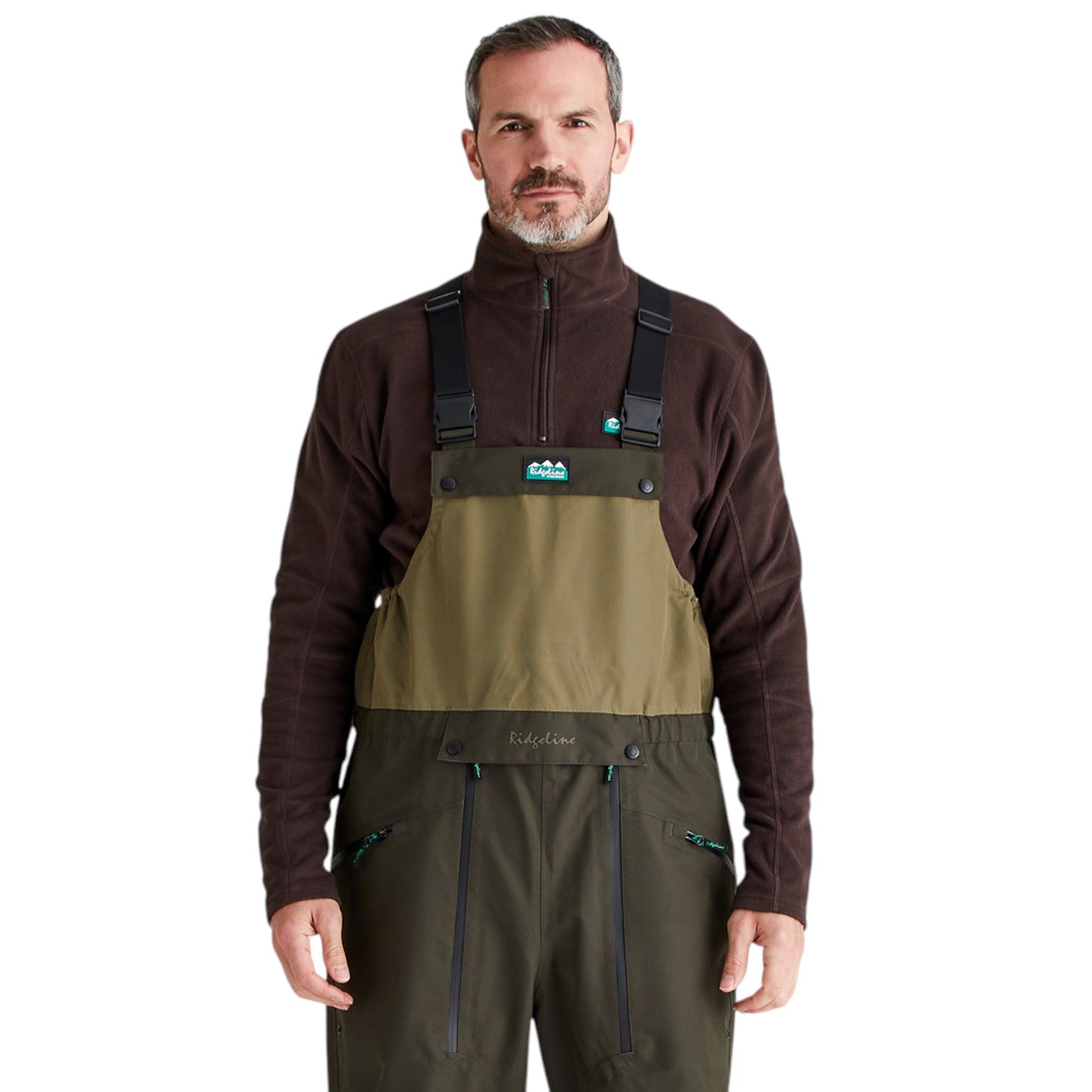 A man wearing a pair of outdoor waders over a dark brown quarter-zip fleece top, photographed against a solid white background. The waders feature a tan chest panel and dark olive green legs.