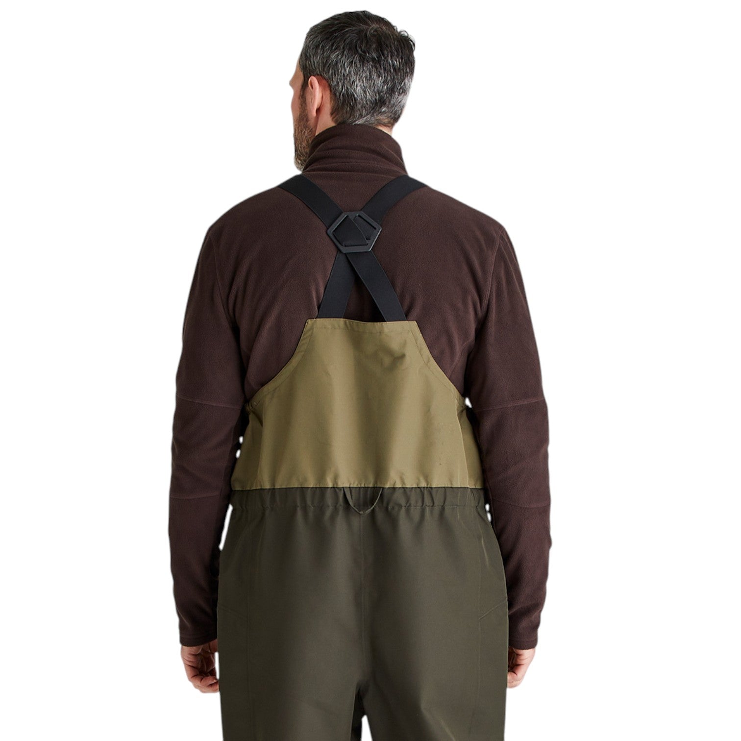A man viewed from the back wearing a three-color waders suit over a dark brown fleece shirt. The waders feature a dark brown upper section, an olive green bib panel, and dark olive green legs, with black suspenders.