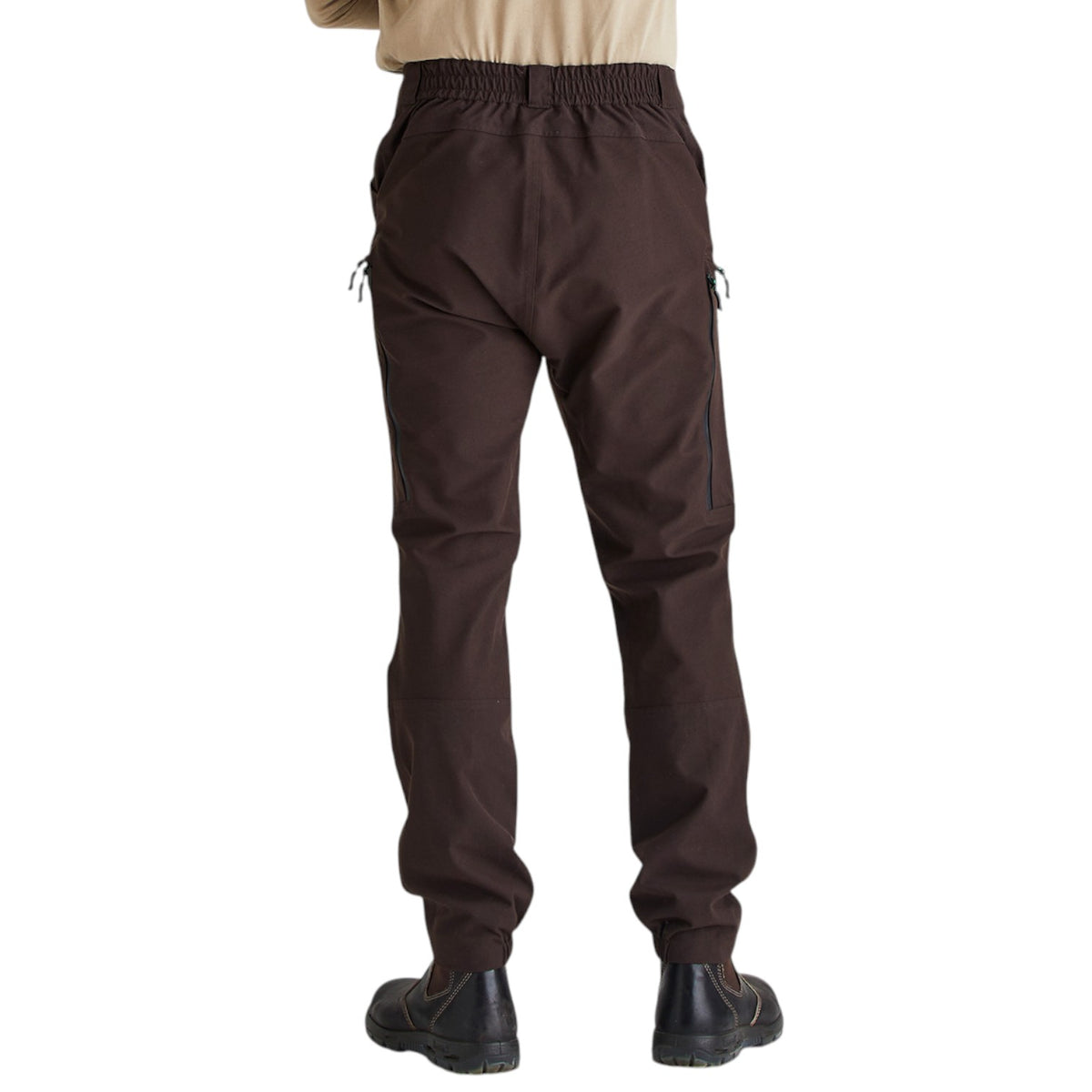 A person shown from the back wearing dark brown cargo-style pants with an elastic waistband and black shoes, against a plain white studio background.