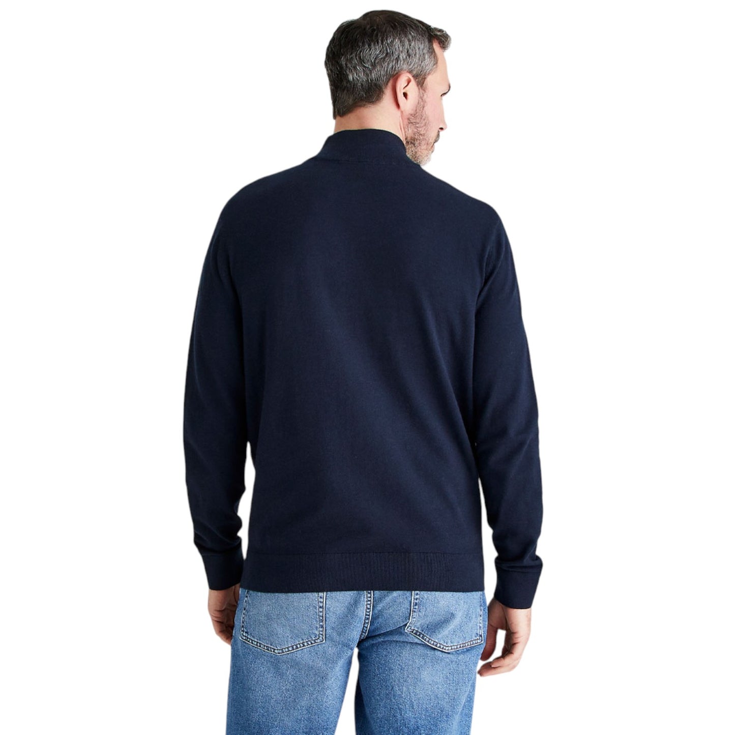 A man viewed from the back wearing a dark navy blue knit sweater and blue jeans against a plain white background.