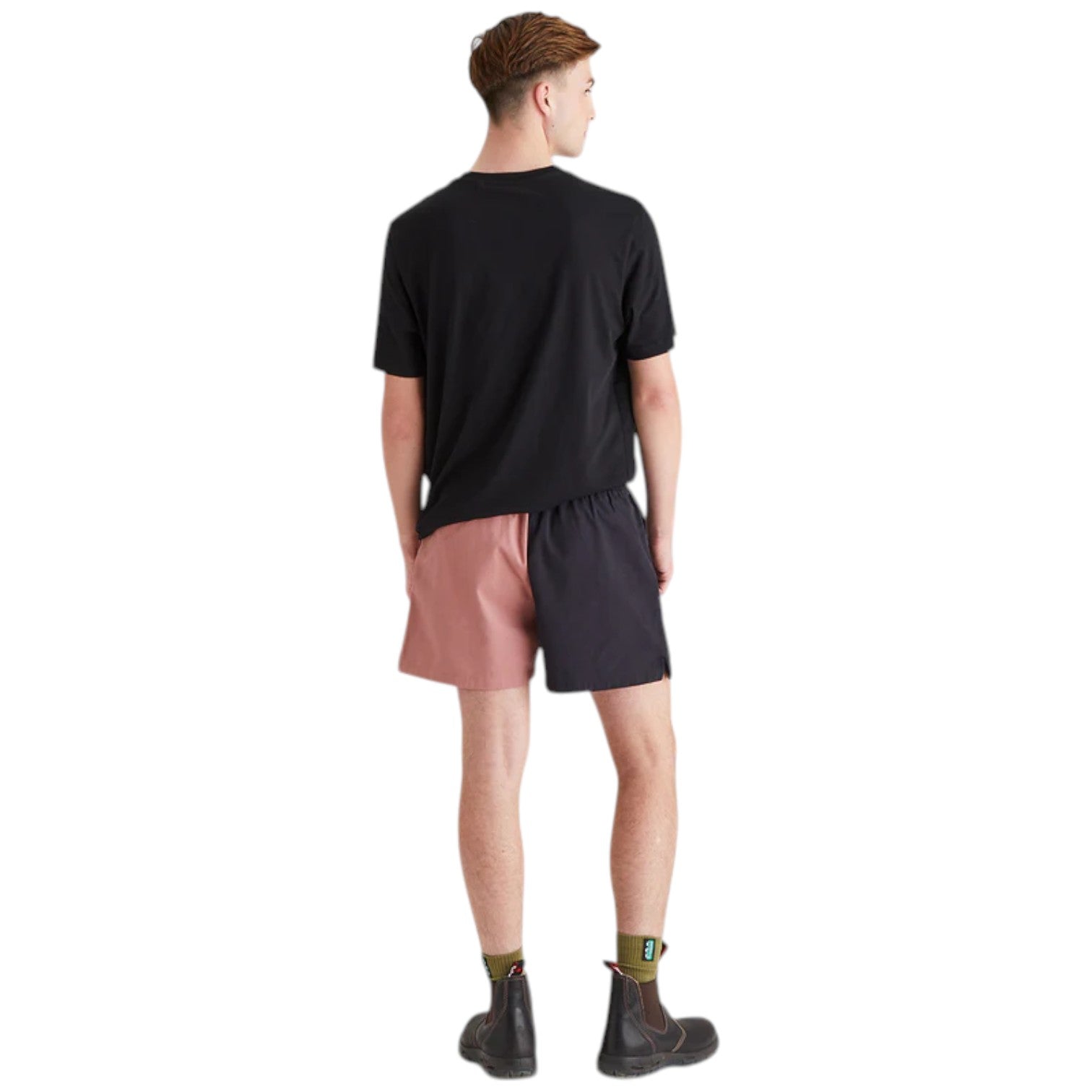 Person wearing a black t-shirt and pink shorts on a white background