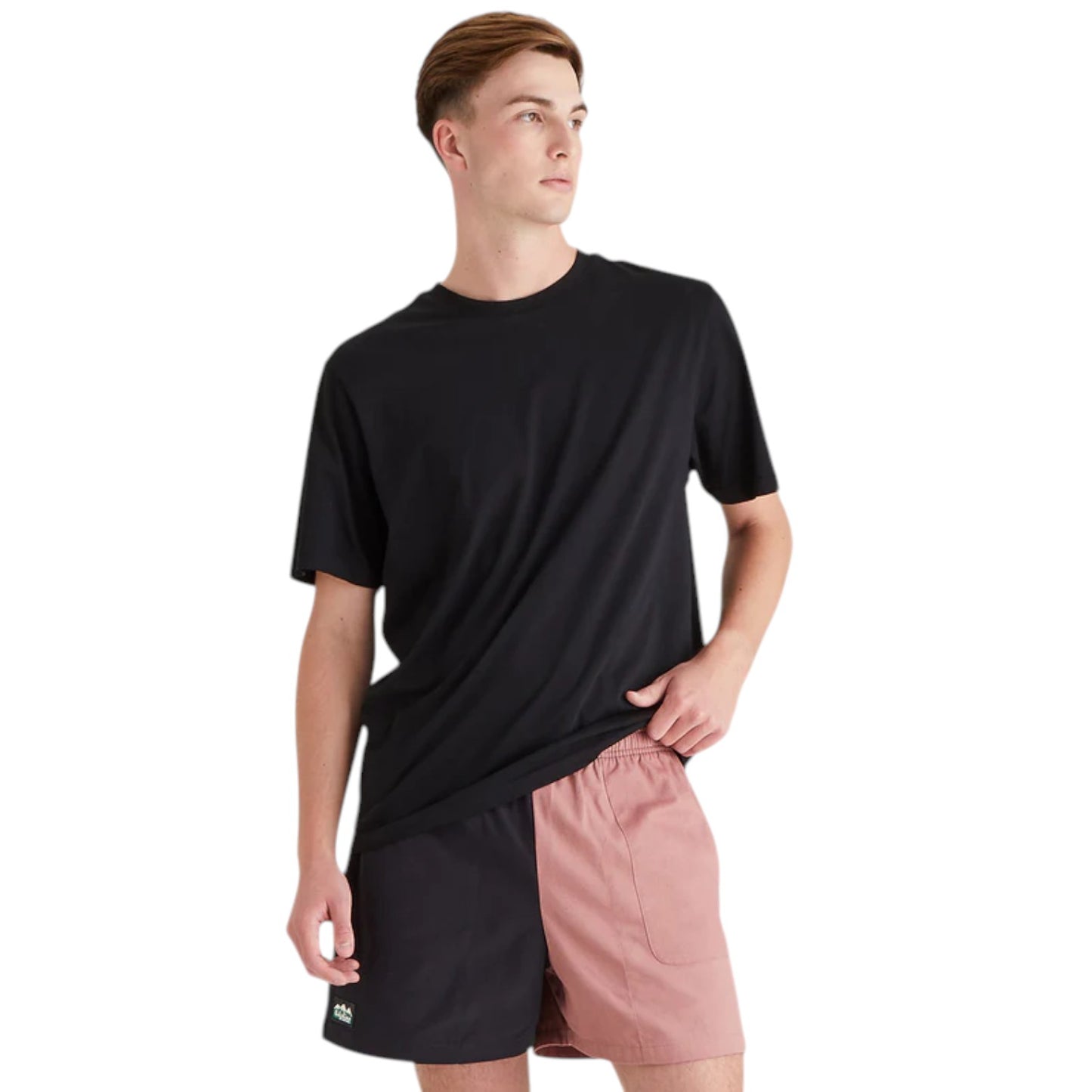 Person wearing a black t-shirt and pink shorts on a white background
