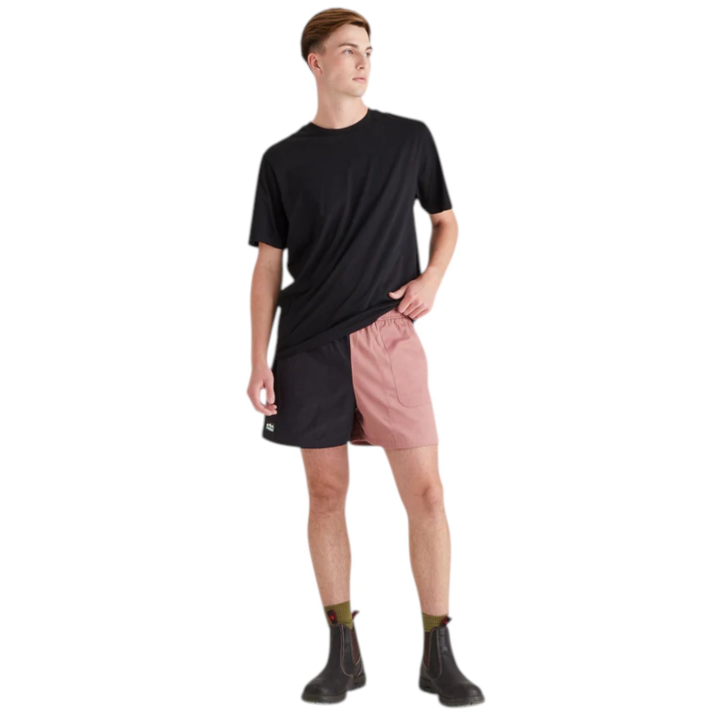 Person wearing a black t-shirt and pink shorts on a white background
