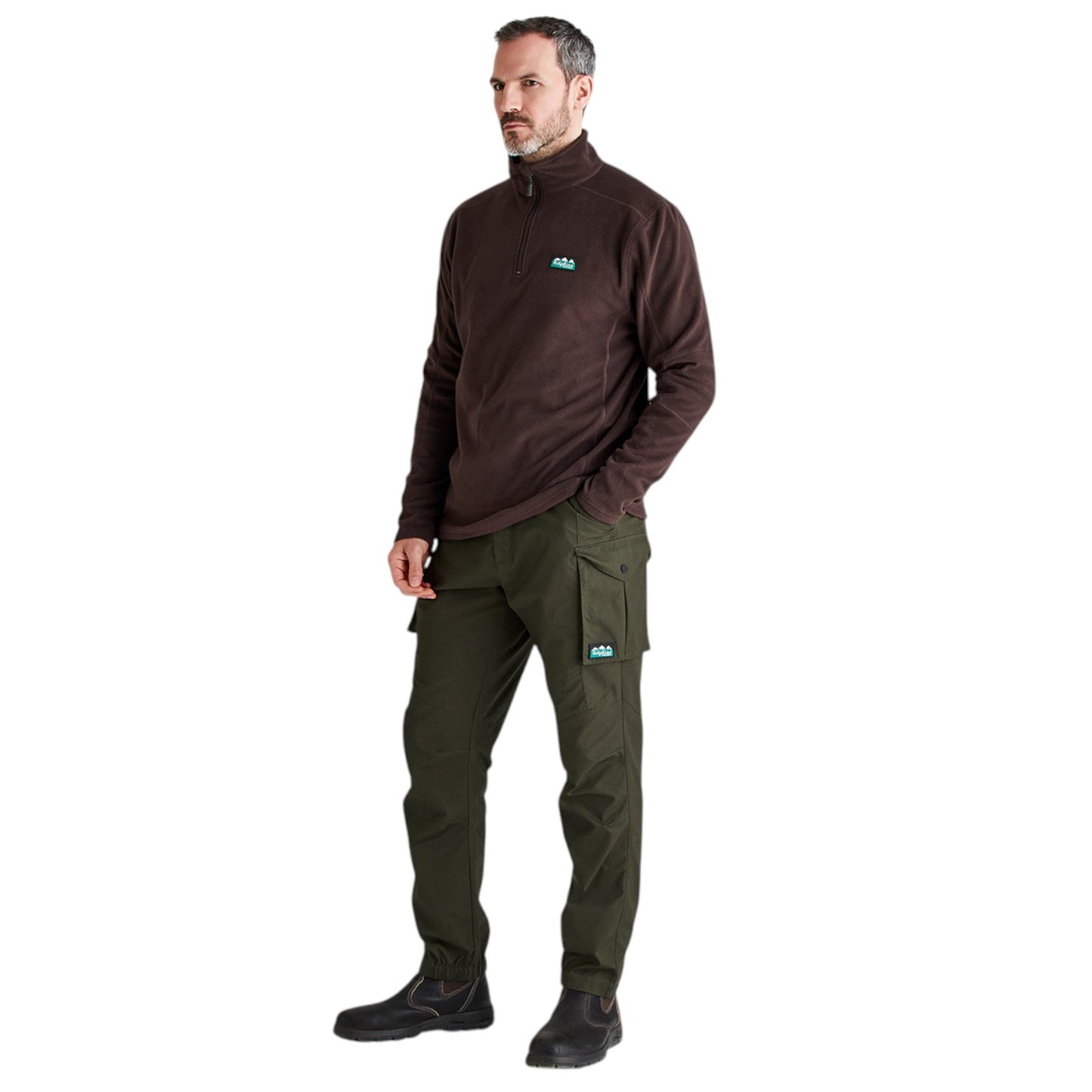A man modeling a dark brown quarter-zip fleece pullover and olive green cargo pants with small turquoise ALO logos on the chest and thigh, set against a plain white background.