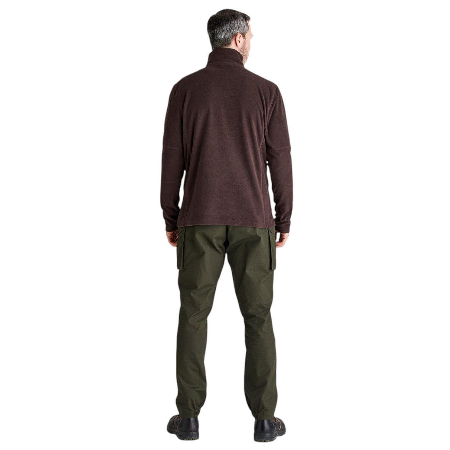 A man viewed from the back wearing a dark brown long-sleeve quarter-zip fleece and olive green pants, standing against a solid white background.