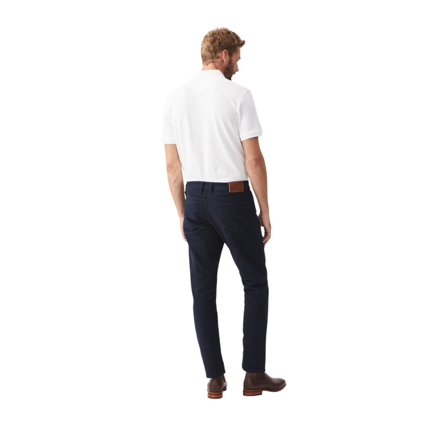 Man wearing a white polo shirt and dark pants on a white background