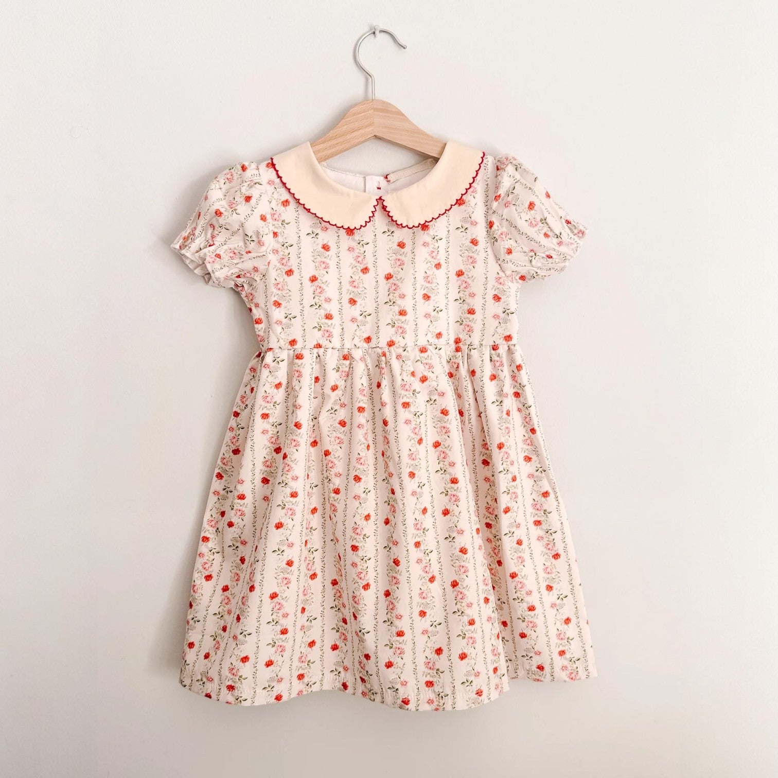 Floral dress on a hanger against a plain background