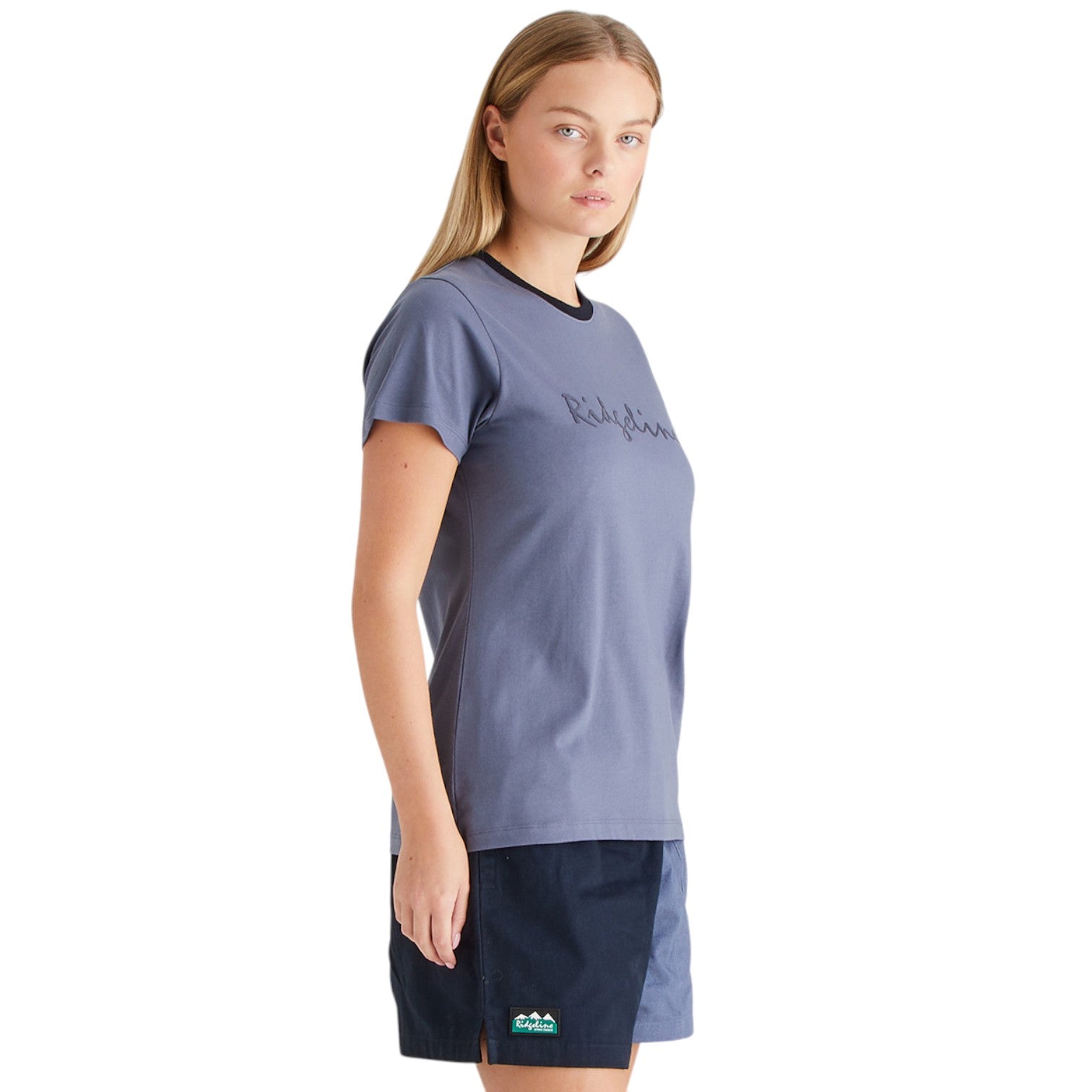 Woman wearing a blue t-shirt and navy shorts on a white background