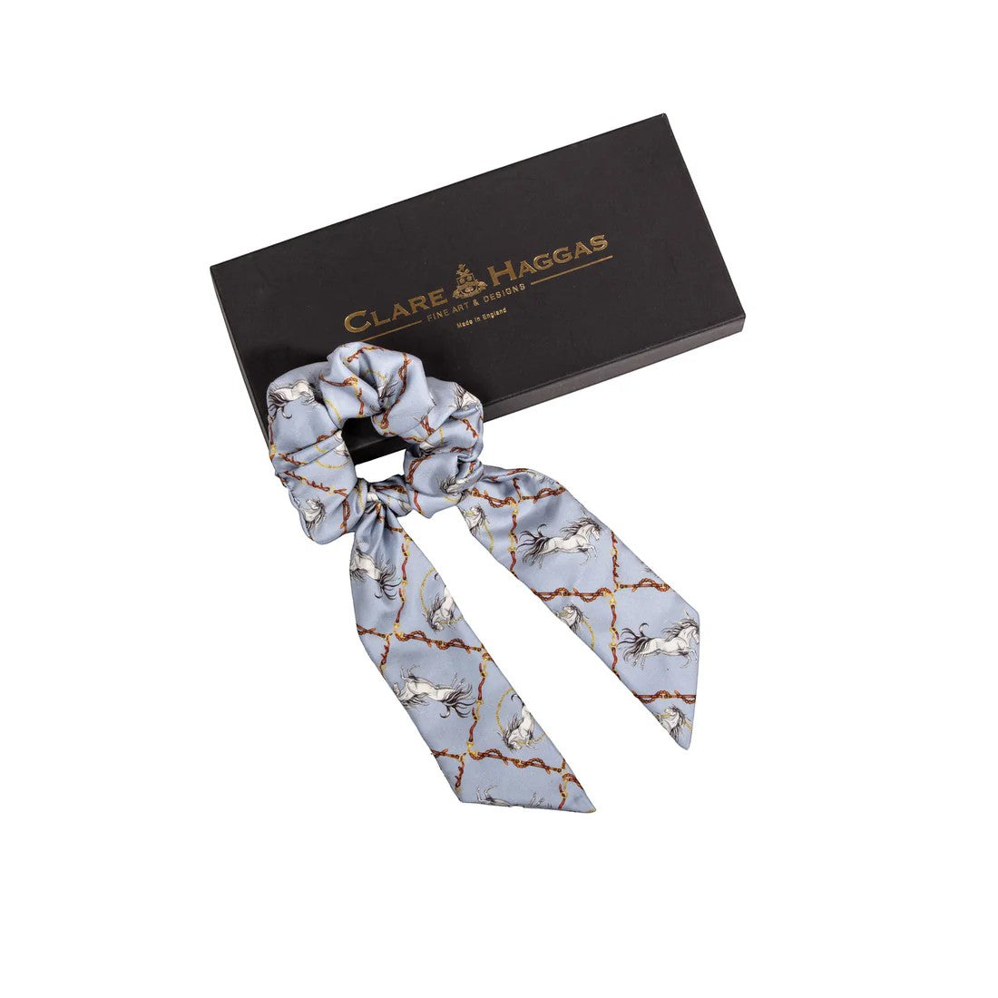 Clare Haggas hair scrunchie with gold accents on a white background