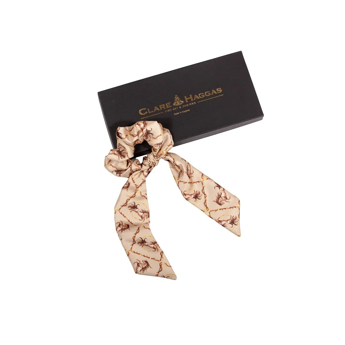 Patterned hair tie with a black box featuring 'Clare Haggas' branding on a white background